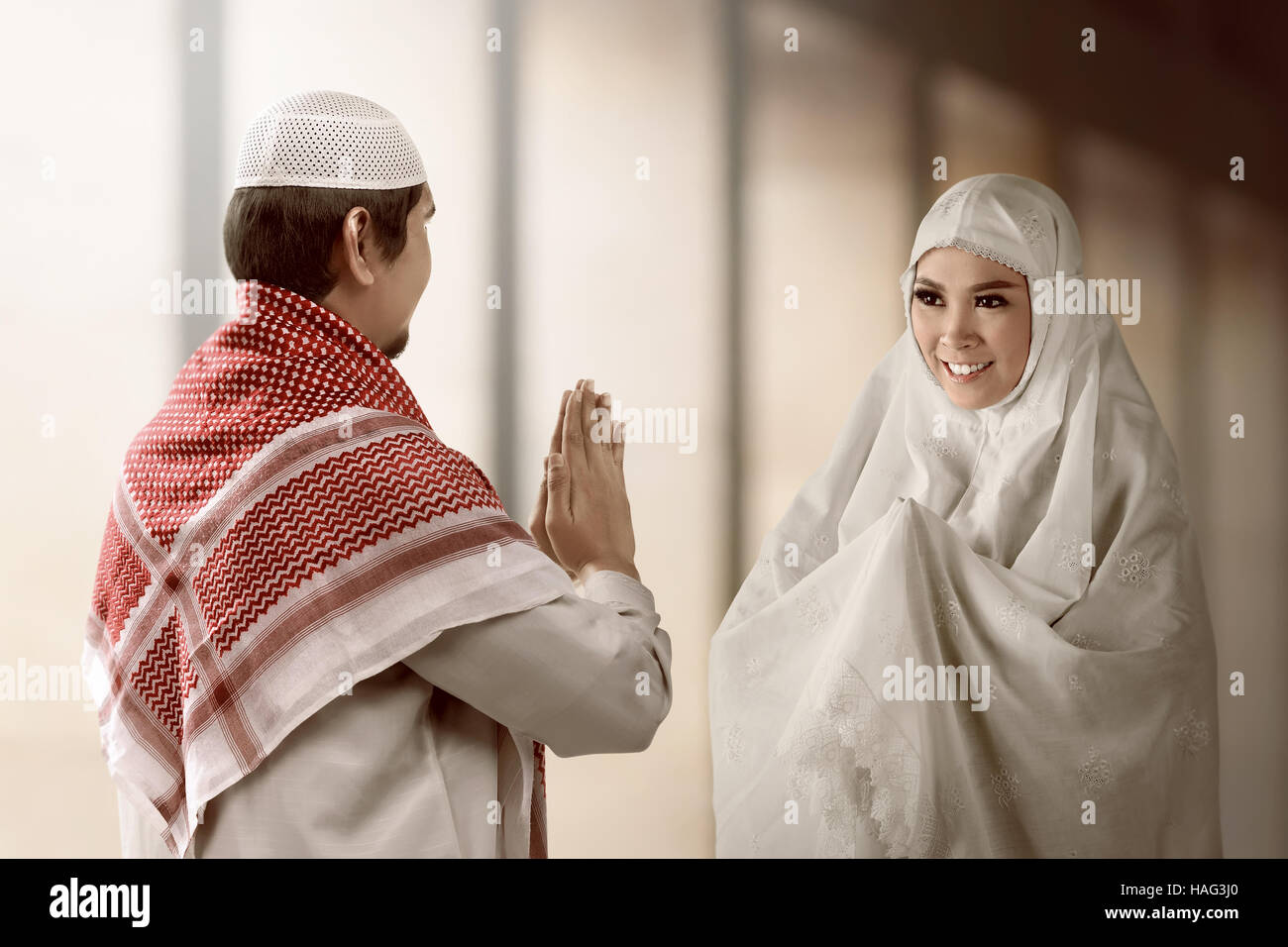 Asiatische muslimischen Mann und Frau grüßen einander mit der muslimischen Tradition mit Moschee