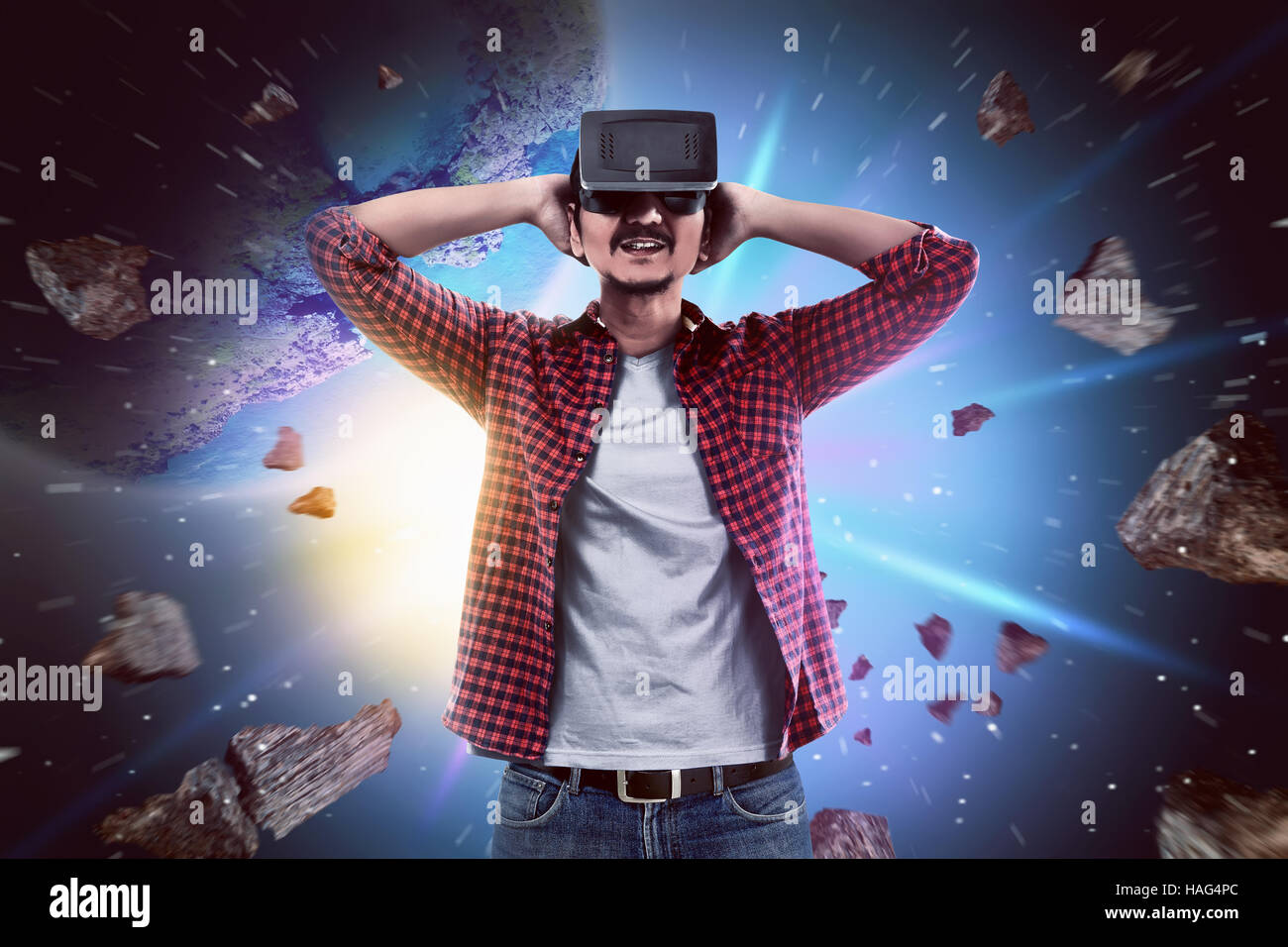 Junge asiatische Mann Verschleiß VR Kopfhörer bekommen in virtual-Reality- Welt Stockfotografie - Alamy