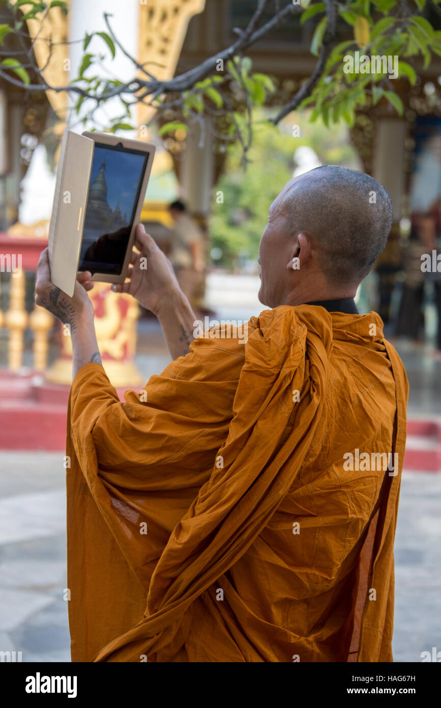 Ein buddhistischer Mönch mit einem Ipad, um die Kuthodew-Pagode in Mandalay, Myanmar (Burma) zu fotografieren. Stockfoto