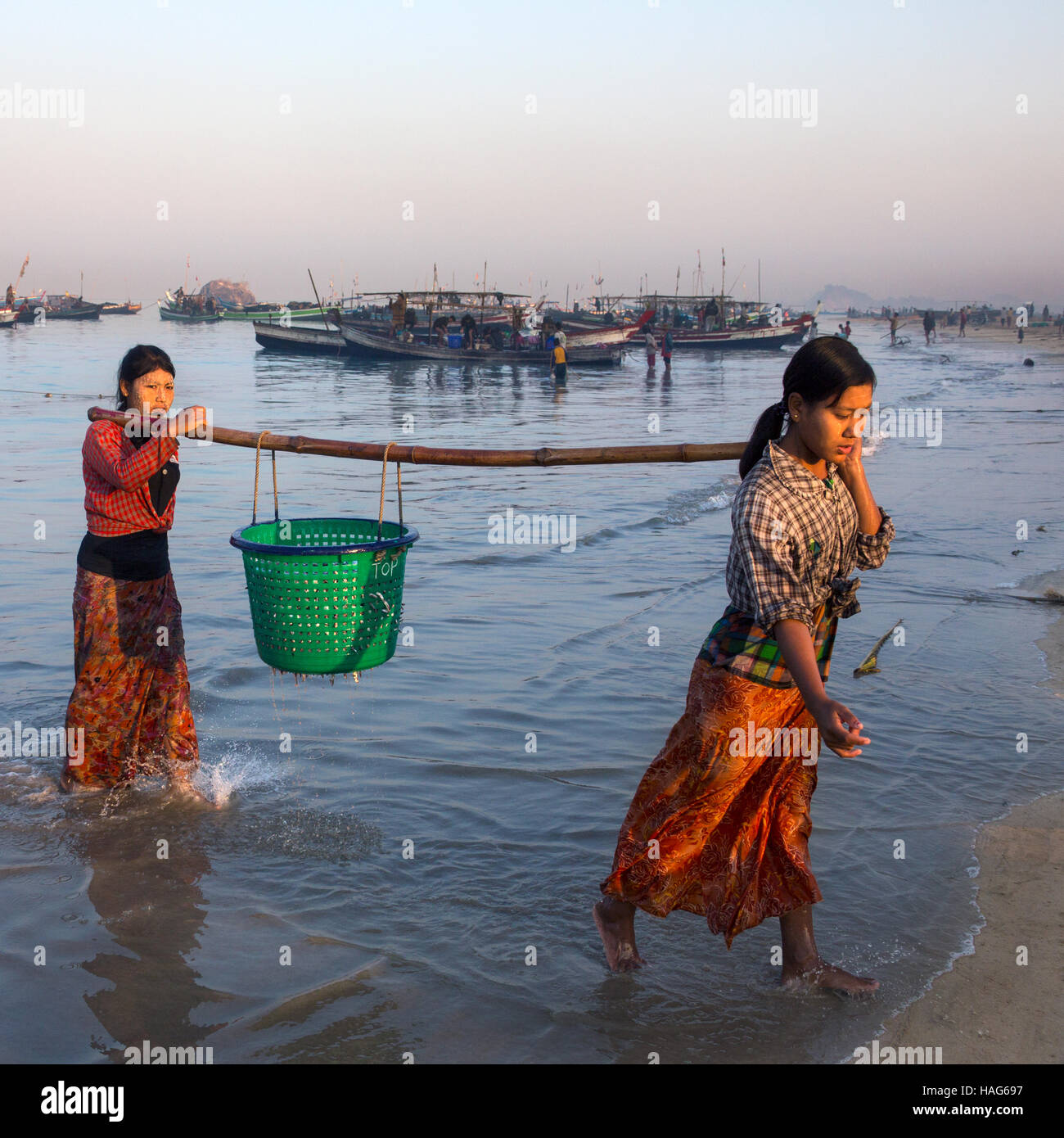 Burmesische Frau bringen die Nächte fangen an Land im Morgengrauen, in der Nähe des Fischerdorfes am Ngapali Strand in Myanmar (Burma). Stockfoto