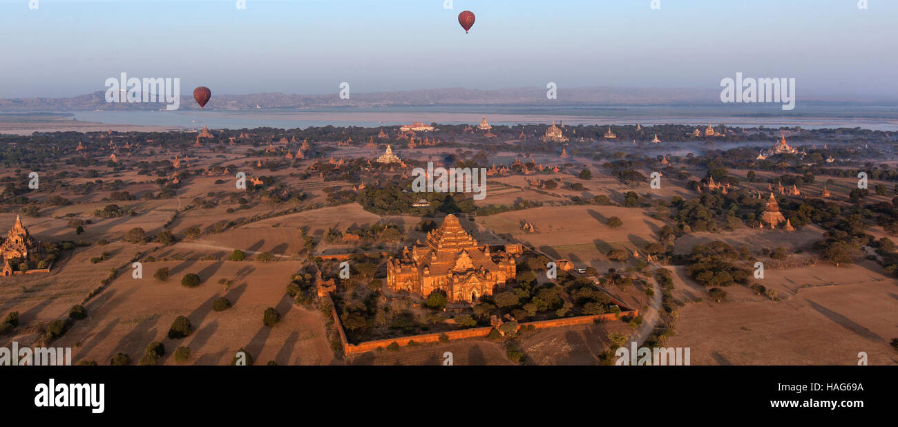 Heißluftballons fliegen über die Tempel von der archäologischen Zone in Bagan in der frühen Morgensonne. Myanmar. Stockfoto