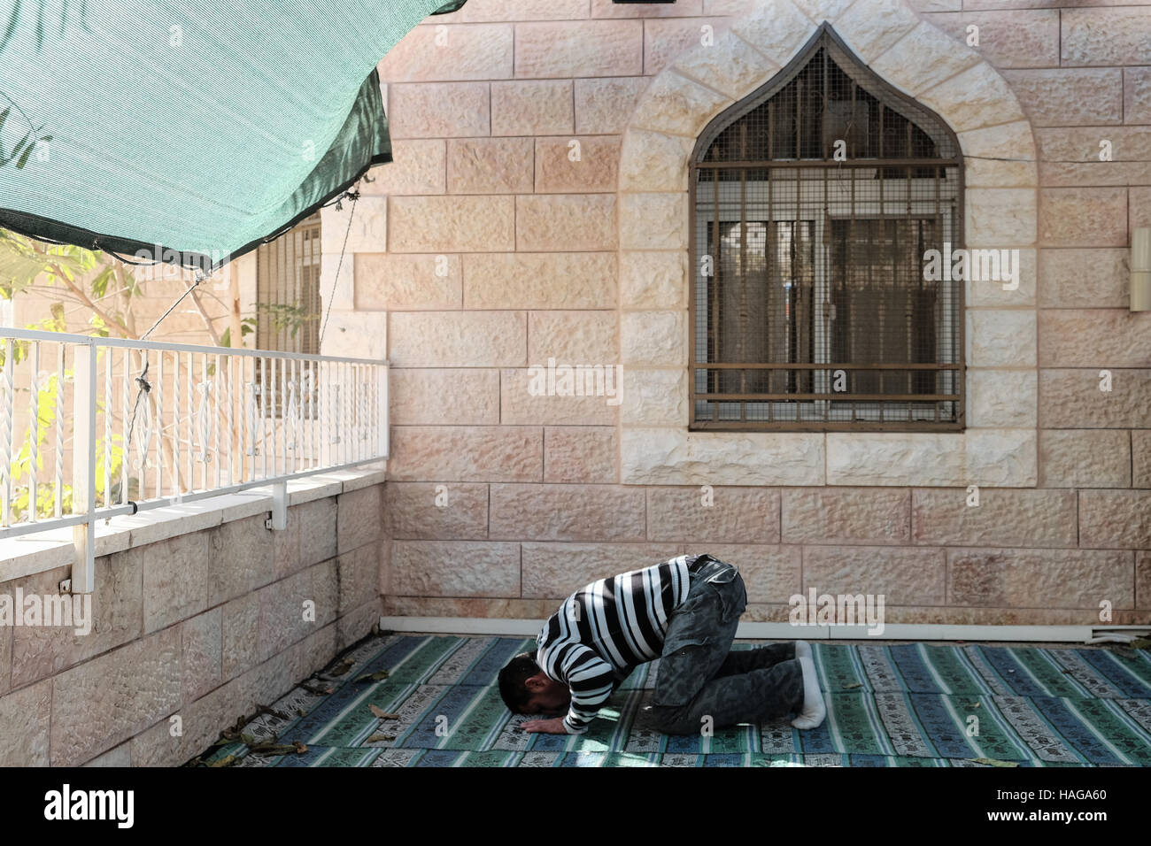 Jerusalem, Israel. 30. November 2016. Ein muslimischer Mann betet vor einer der fünf Moscheen im Dorf Bet Safafa. Die israelische Regierung vorgeschlagene Gesetzgebung Verbot von religiösen Institutionen hindern, Outdoor-Lautsprecher, genannt die "Muazzin Bill", wie in der muslimischen Aufruf zum Gebet die 5 Mal am Tag auftritt. Die Rechnung, beschriftet eine Bedrohung für die muslimischen Gemeinden und einen Umzug von der israelischen Regierung zum Herunterfahren Moscheen, soll eine vorläufige Abstimmung kommen. Bildnachweis: Nir Alon/Alamy Live-Nachrichten Stockfoto
