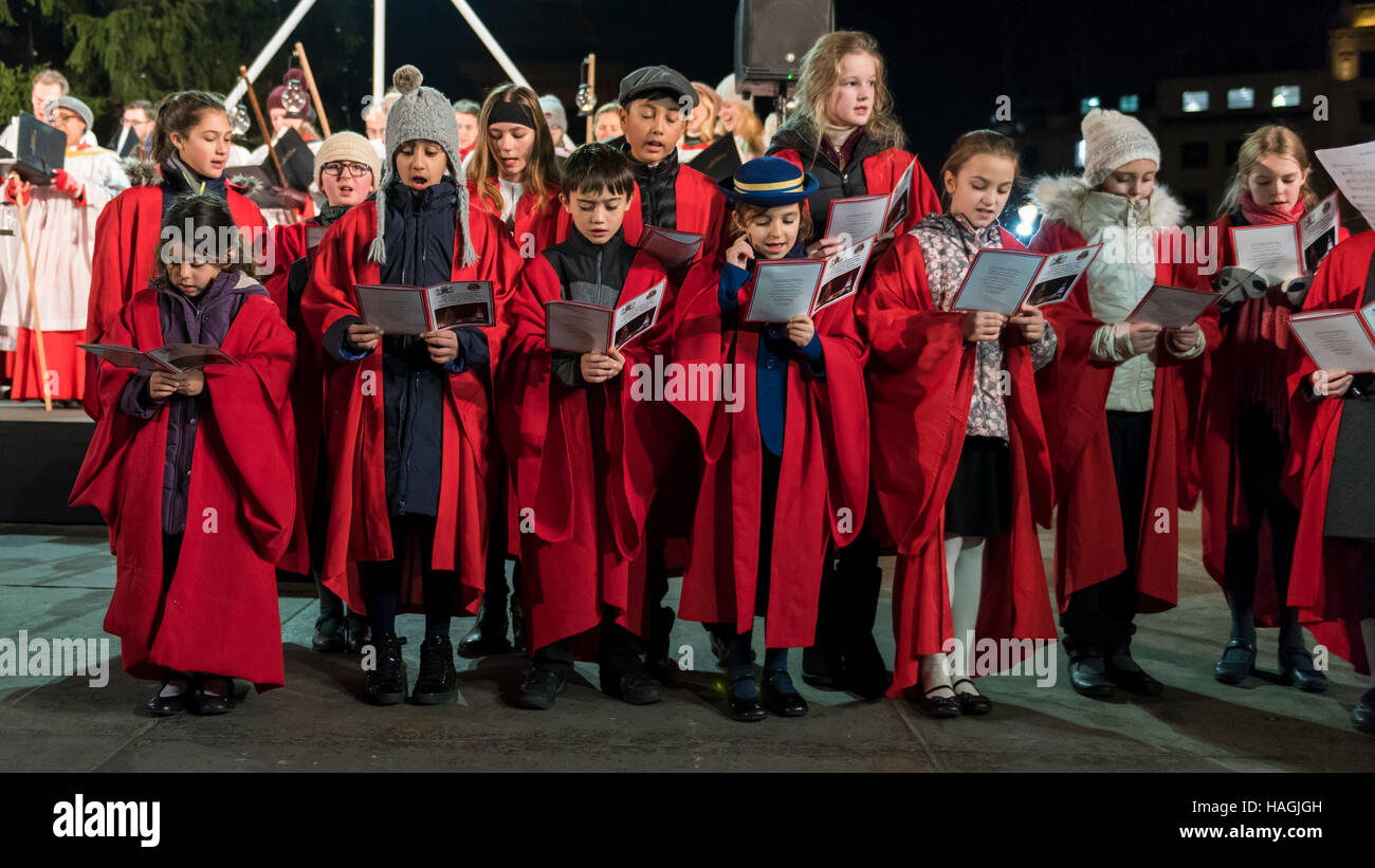 London, UK.  1. Dezember 2016. Der Chor der St. Martins-in-the-Fields, Kinder Voices Choir singen Weihnachtslieder als ein 22-Meter hohen Norwegische Fichte, eingerichtet im traditionellen norwegischen Stil mit vertikalen Saiten der Lichter (rund 770 energieeffiziente Leuchtmittel) leuchtet am Trafalgar Square.  Der Baum ist der Stadt Oslo traditionelle Weihnachtsgeschenk an London als Zeichen des Dankes für die britische Unterstützung während des zweiten Weltkriegs. Bildnachweis: Stephen Chung / Alamy Live News Stockfoto