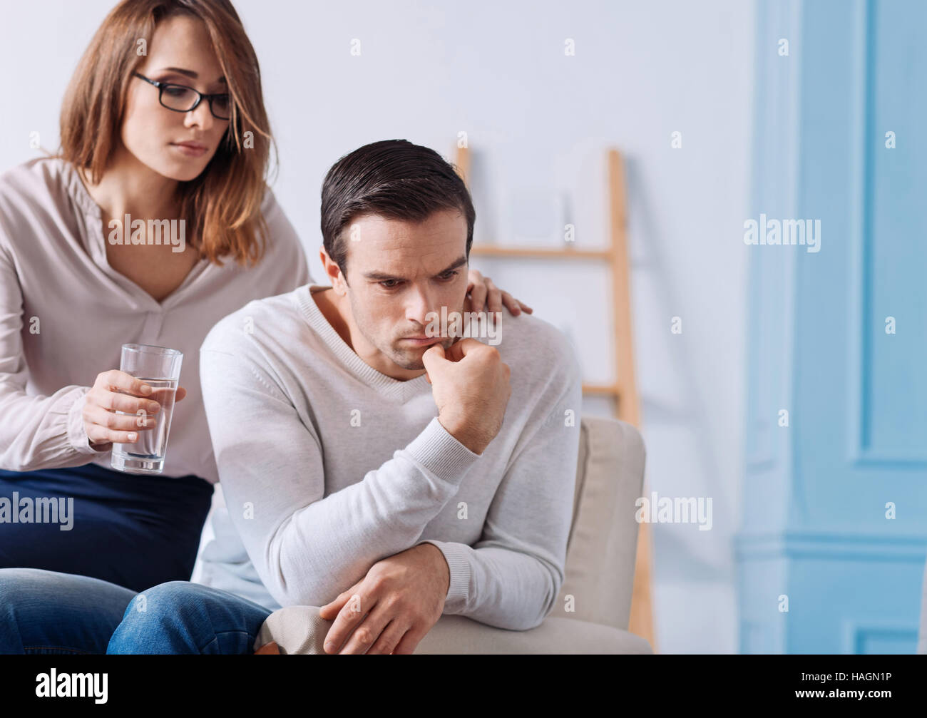 Notleidende Mann sitzt zu Hause mit seiner Frau. Stockfoto