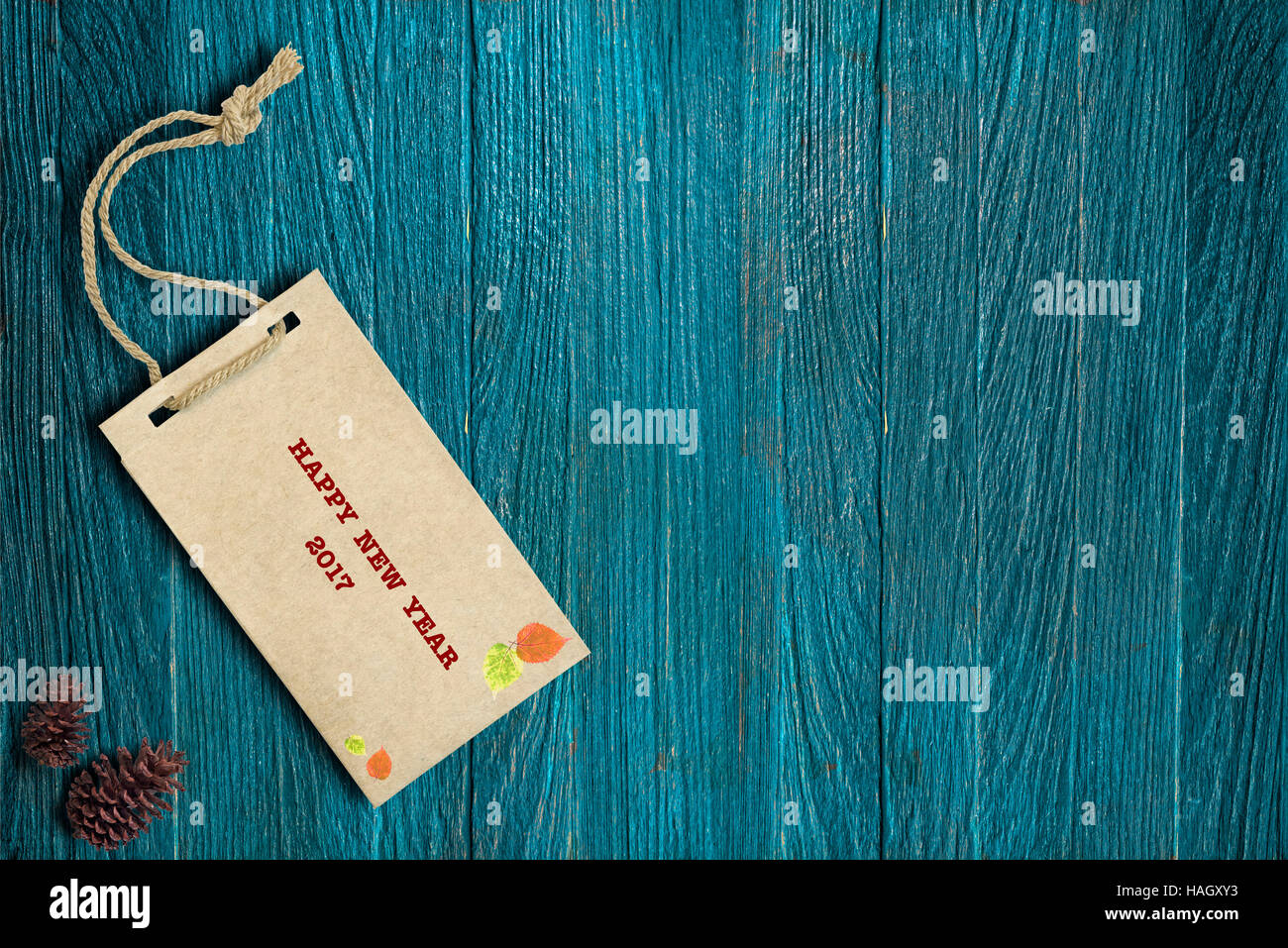 Packpapier-Tag mit Wort frohes neues Jahr 2017 auf blauem Hintergrund aus Holz. Stockfoto