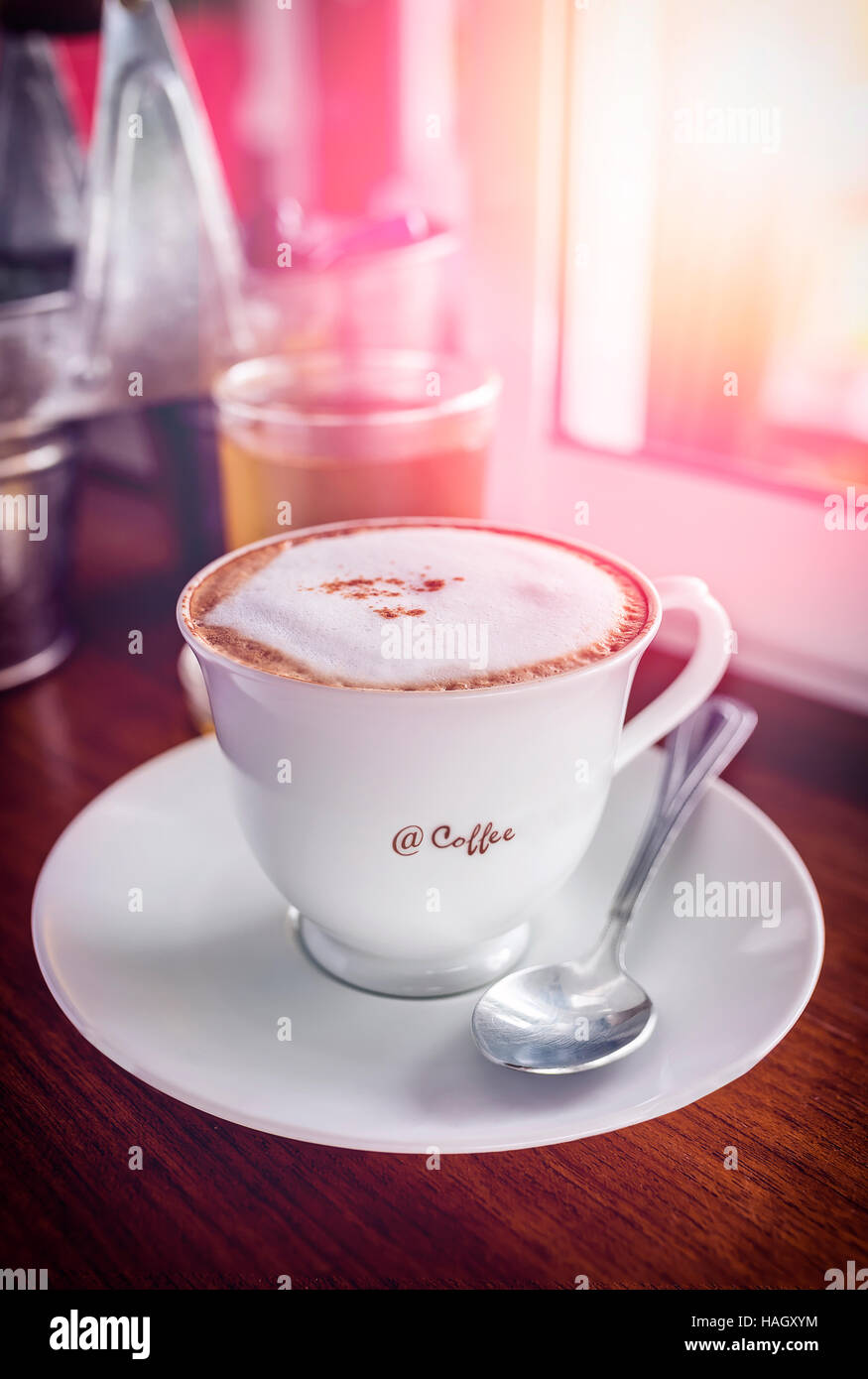 Weiße Tasse Kaffee auf Holztisch im Morgenlicht, Vintage Farbton. Stockfoto