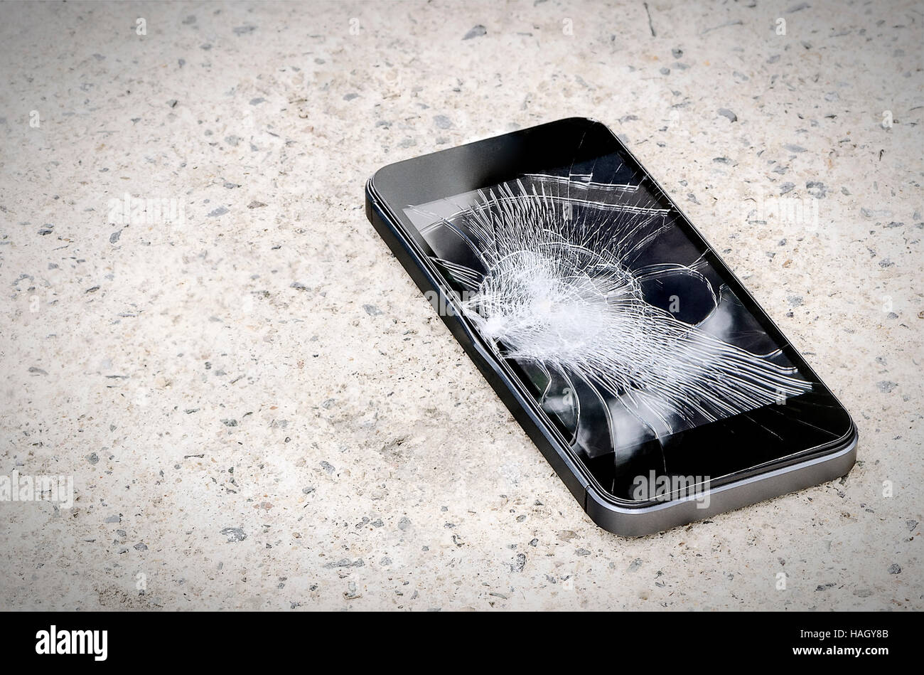 Smartphone mit gebrochenen Bildschirm auf dem Boden. Stockfoto