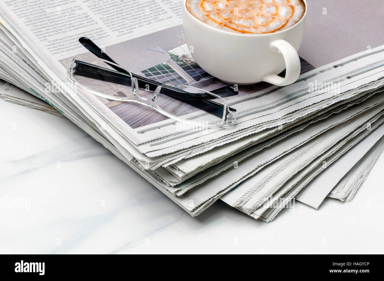 Stapel von Zeitung, Kaffee und Brillen auf den Tisch. Stockfoto