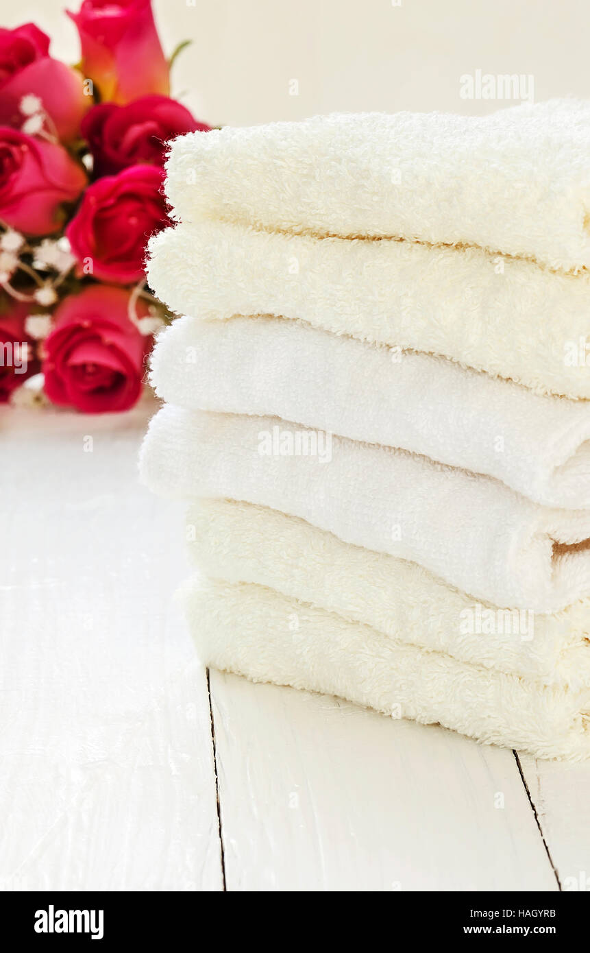 Stapel Handtücher auf weißem Hintergrund aus Holz. Stockfoto