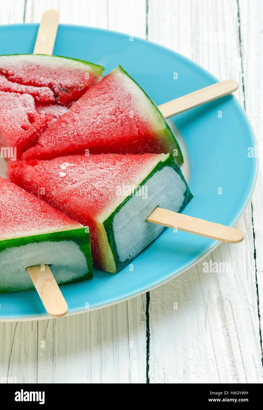 Gekühlte Wassermelone mit Eis klebt auf weißem Hintergrund aus Holz. Stockfoto