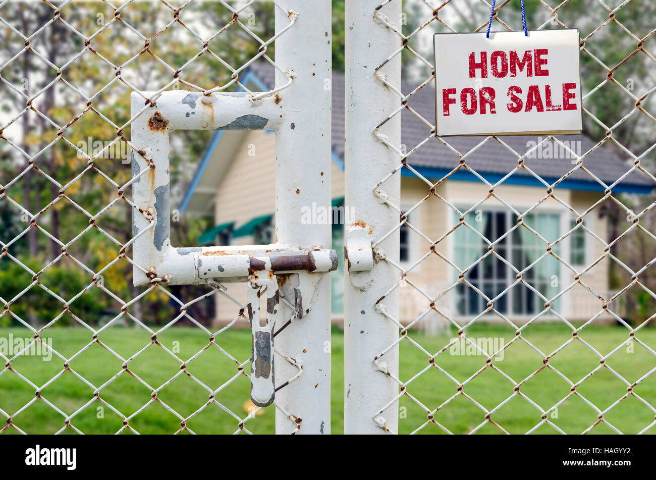 Home For Sale und Real Estate Zeichen auf Maschendrahtzaun Stockfoto