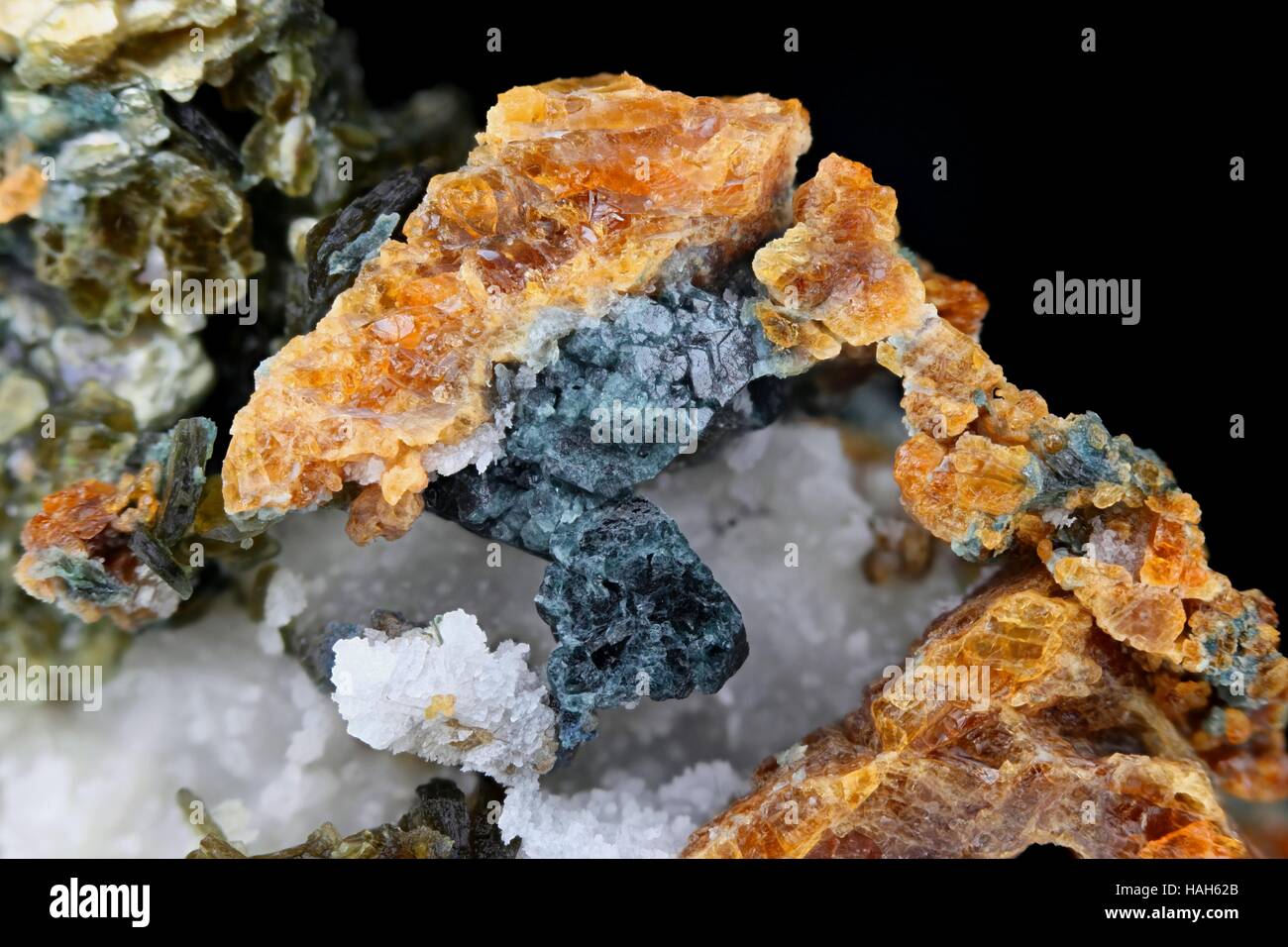 Orange Clinohumite, blauer Spinell, grüner Glimmer und weißen Calcit Stockfoto