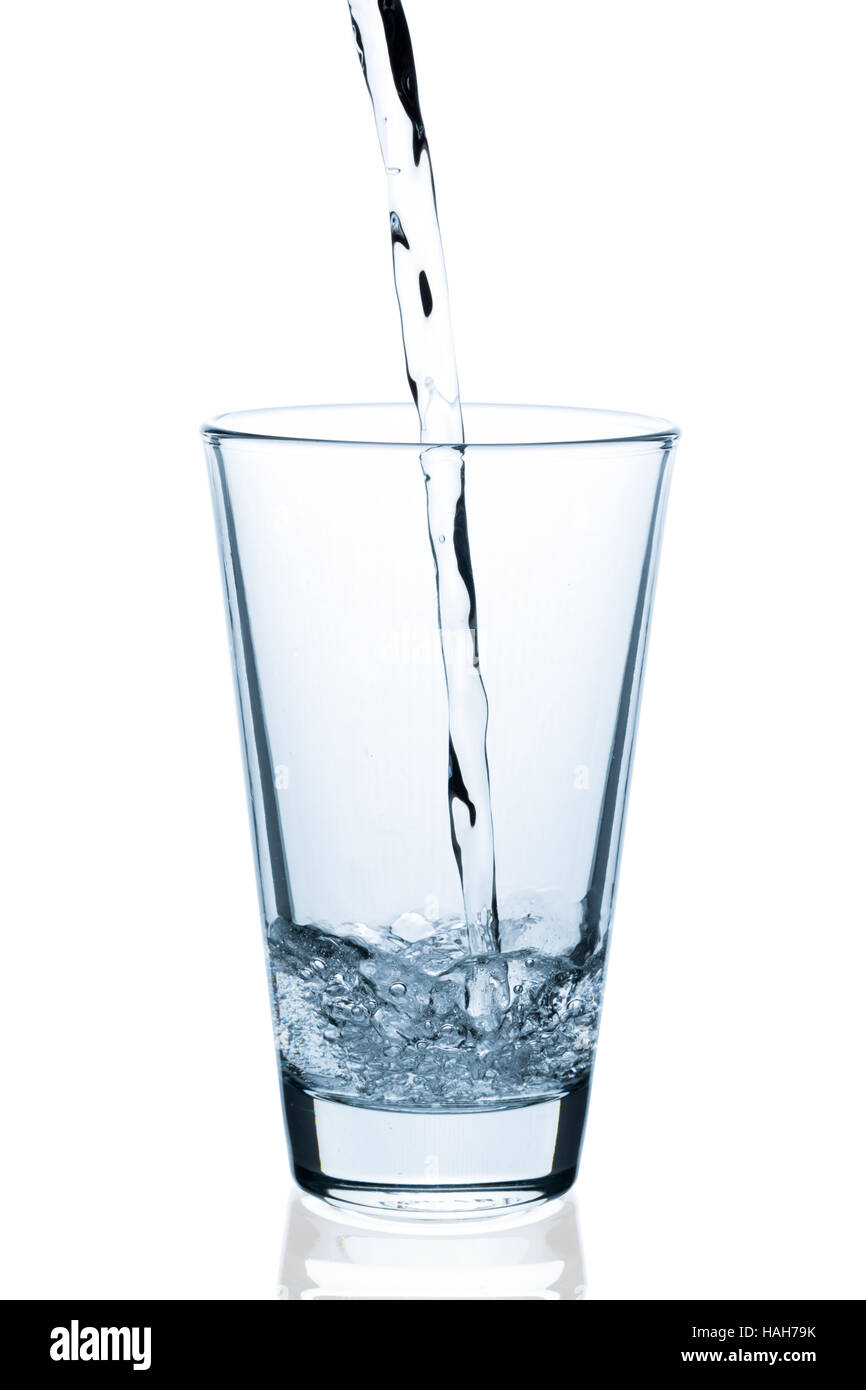 gießen Wasser in Glas isoliert auf weißem Hintergrund Stockfoto