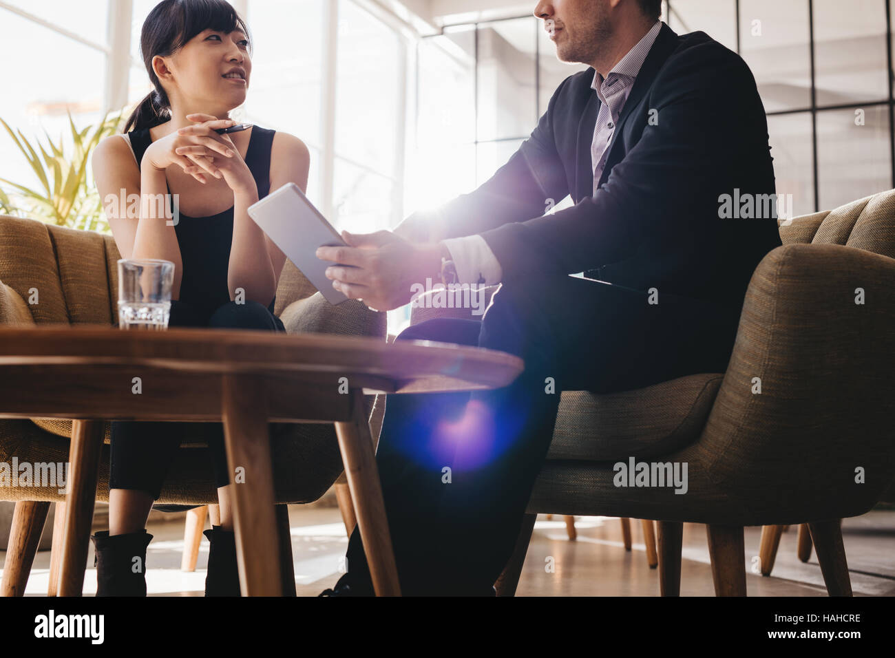 Schuss der Geschäftsmann zeigen etwas auf digital-Tablette, seine Kollegin. Business-Leute treffen im Büro Lobby. Stockfoto