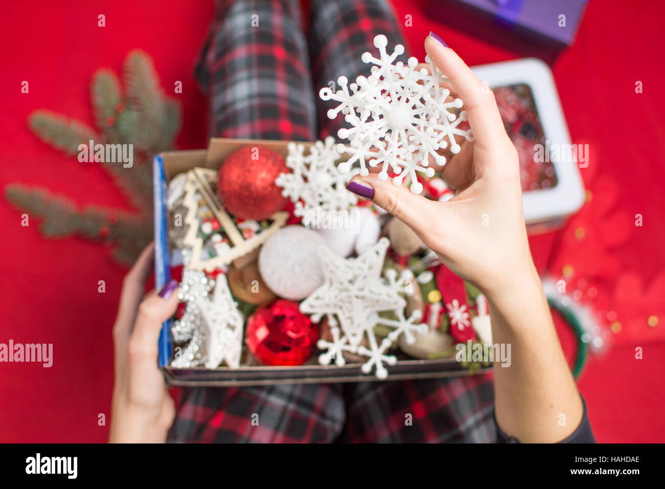 Weibchen mit einer geöffneten Weihnachten Dekoration Box im Pyjama Stockfoto