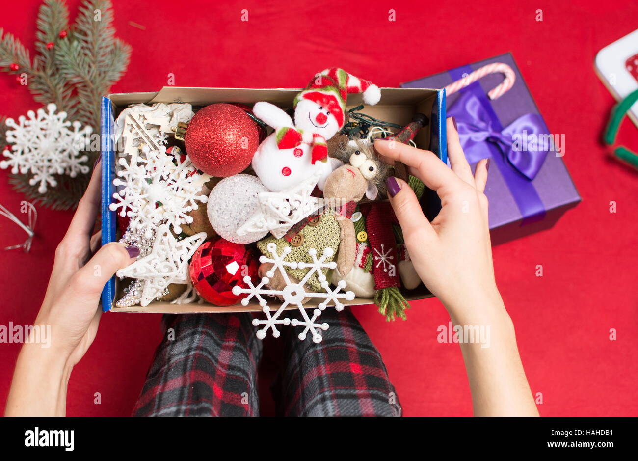 Weibchen mit einer geöffneten Weihnachten Dekoration Box im Pyjama Stockfoto