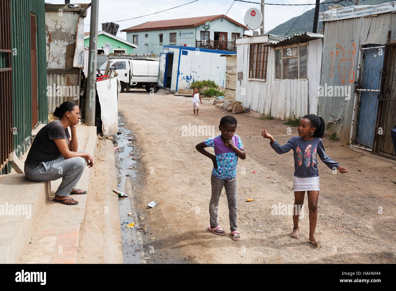 zwei Kinder im Gespräch mit einem Erwachsenen auf der Straße, Township Imizamo Yethu, Cape Town, Südafrika Stockfoto