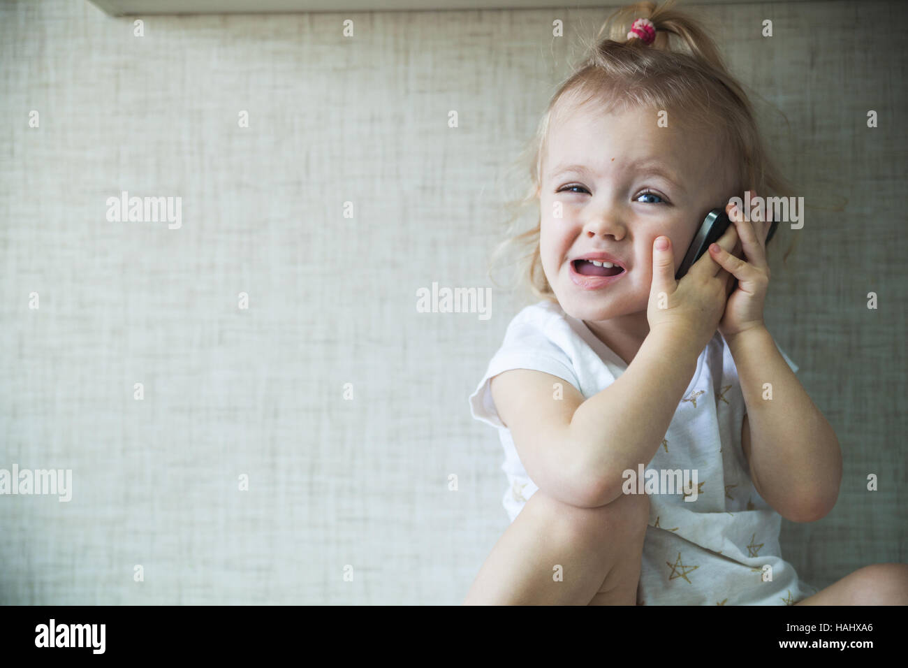 kleines Mädchen Kochen und am Telefon sprechen Stockfoto