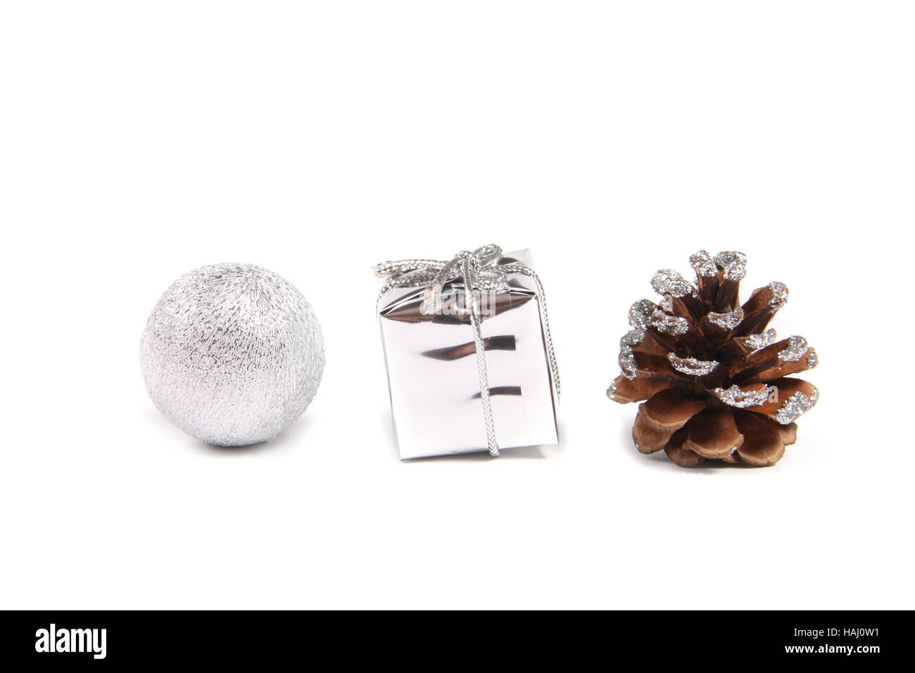 Drei dekorative Objekte für Weihnachten - Ball, Geschenk und Tannenzapfen Stockfoto
