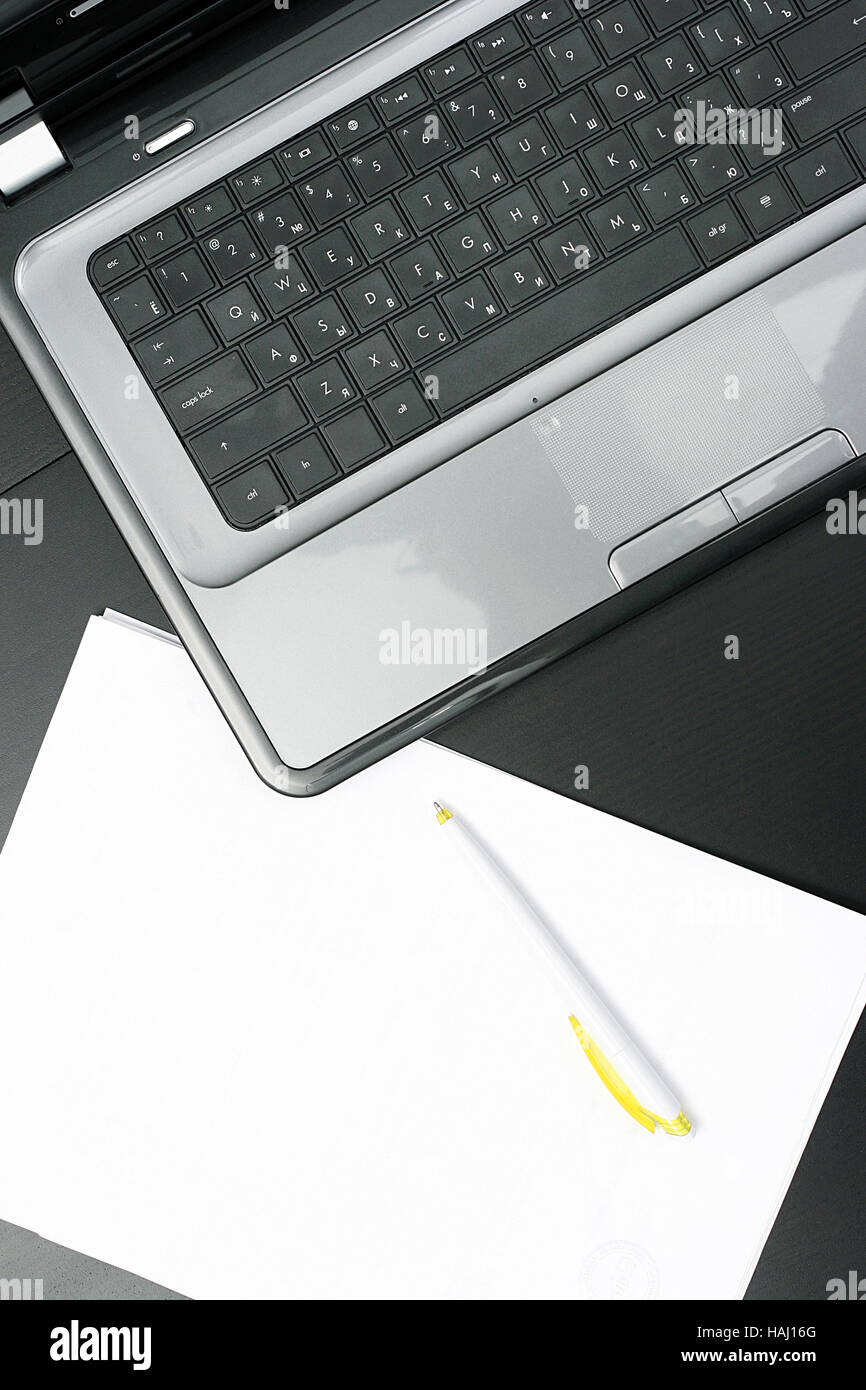 Laptop und leeres Papierblatt auf den Tisch Stockfoto