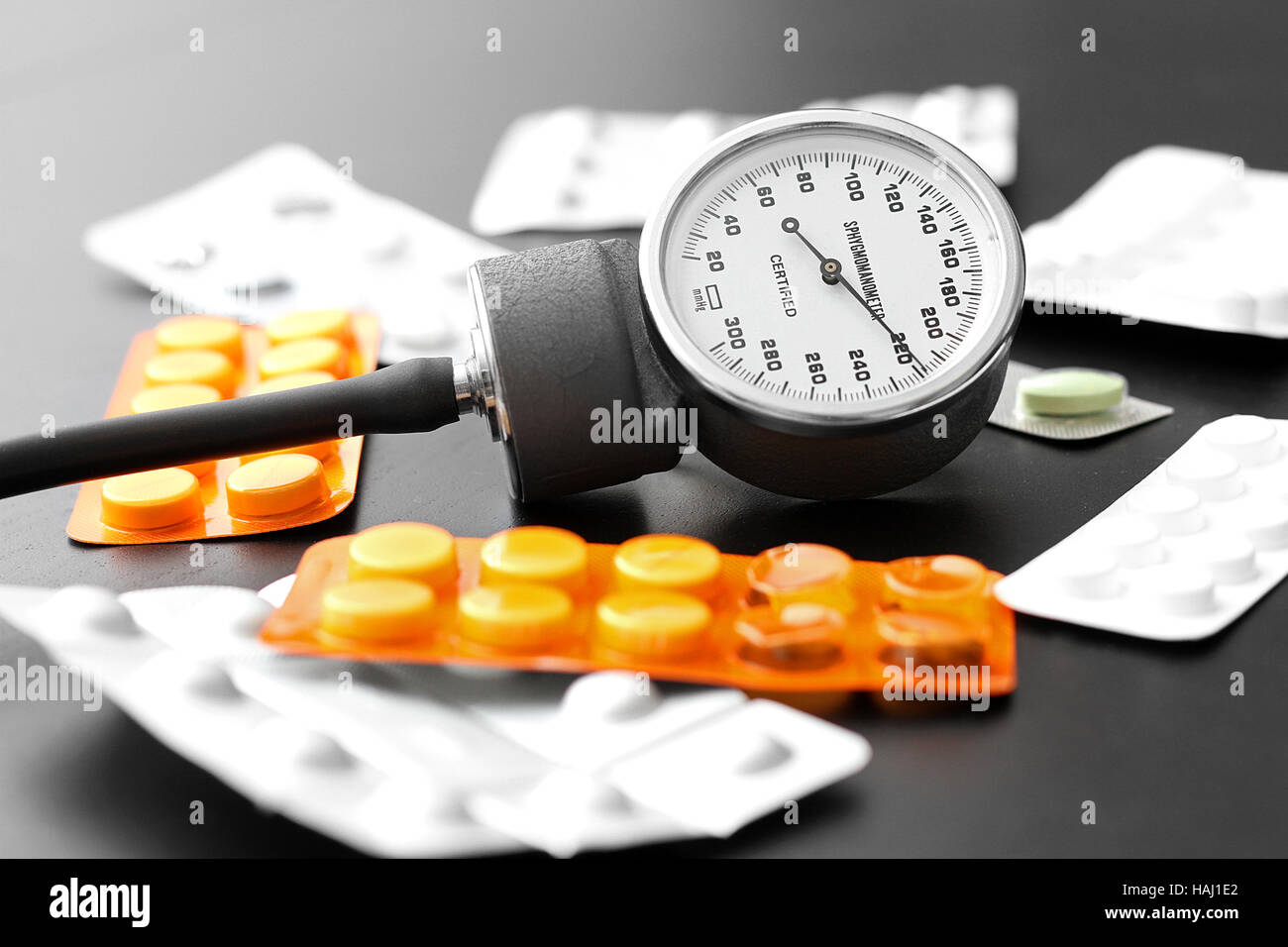 Blutdruck-Messgerät und Pillen auf dem Tisch Stockfoto
