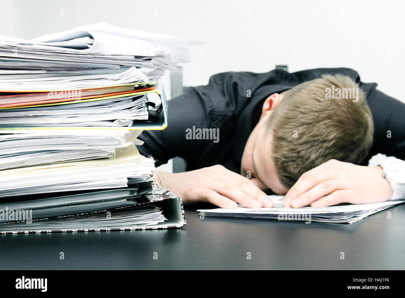 müde Büroangestellte und einen Stapel von Dokumenten Stockfoto