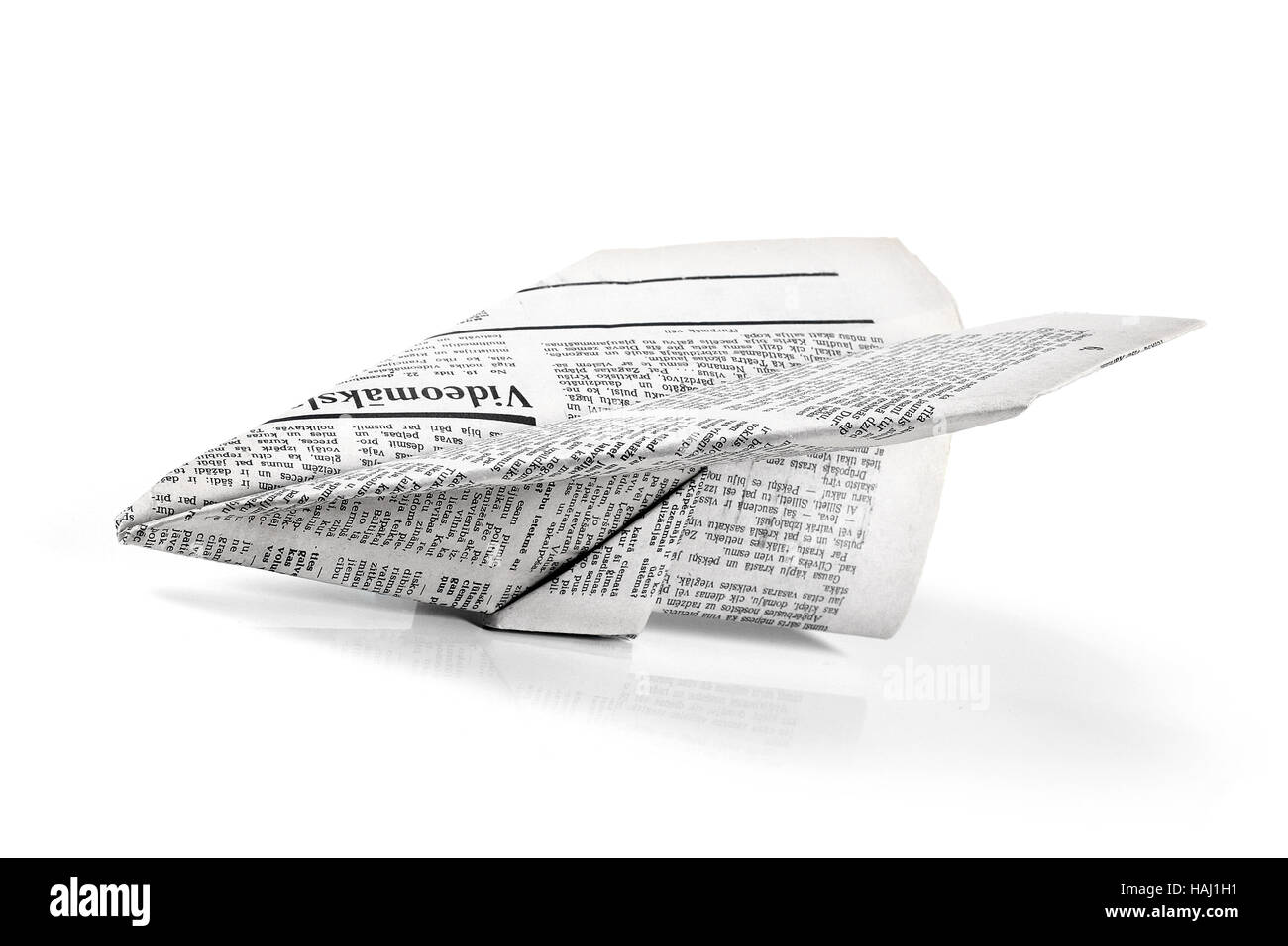 Papierflieger aus Zeitung isoliert auf weiss Stockfoto