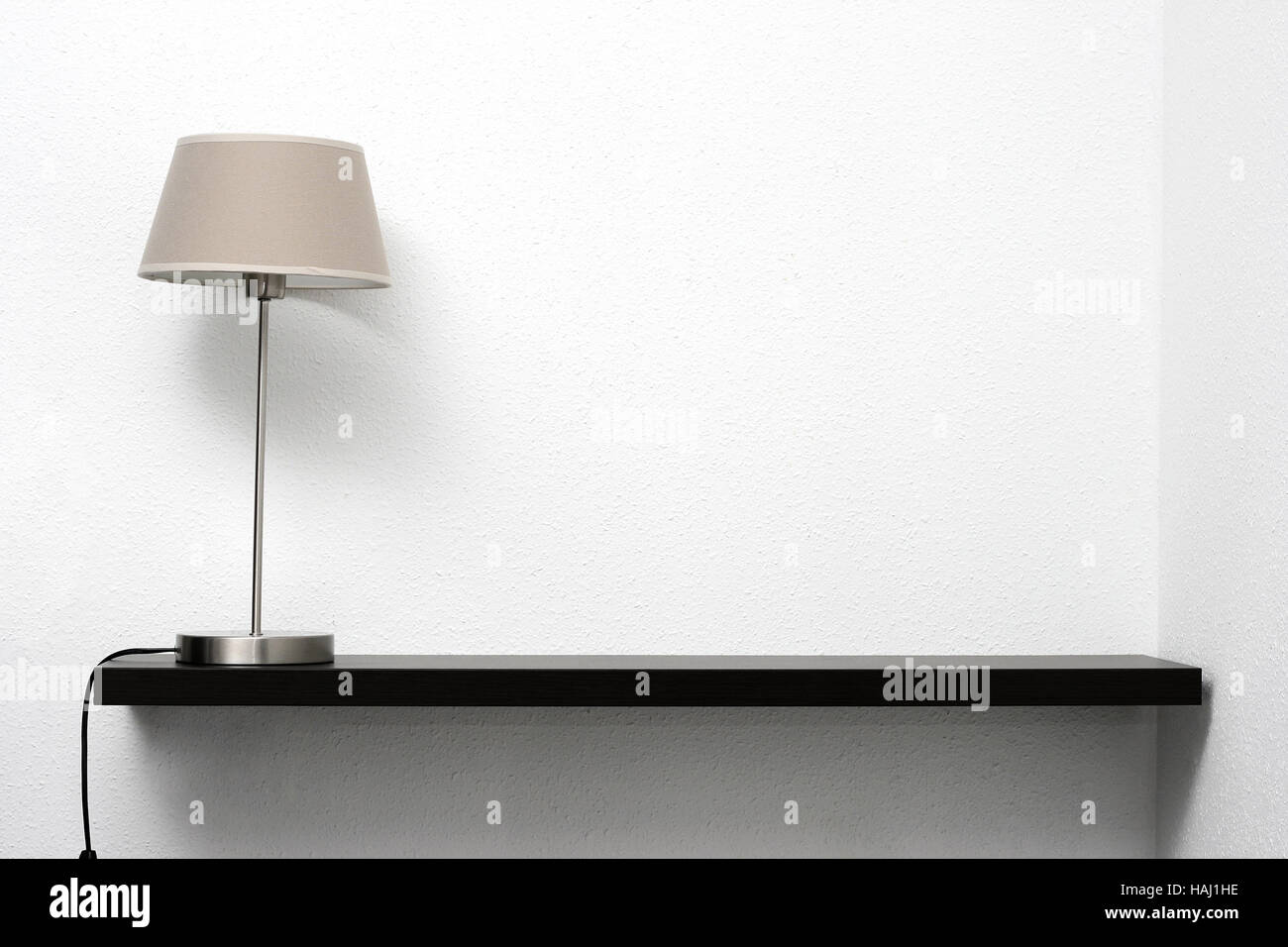 Regal an der Wand mit Lampe Stockfoto