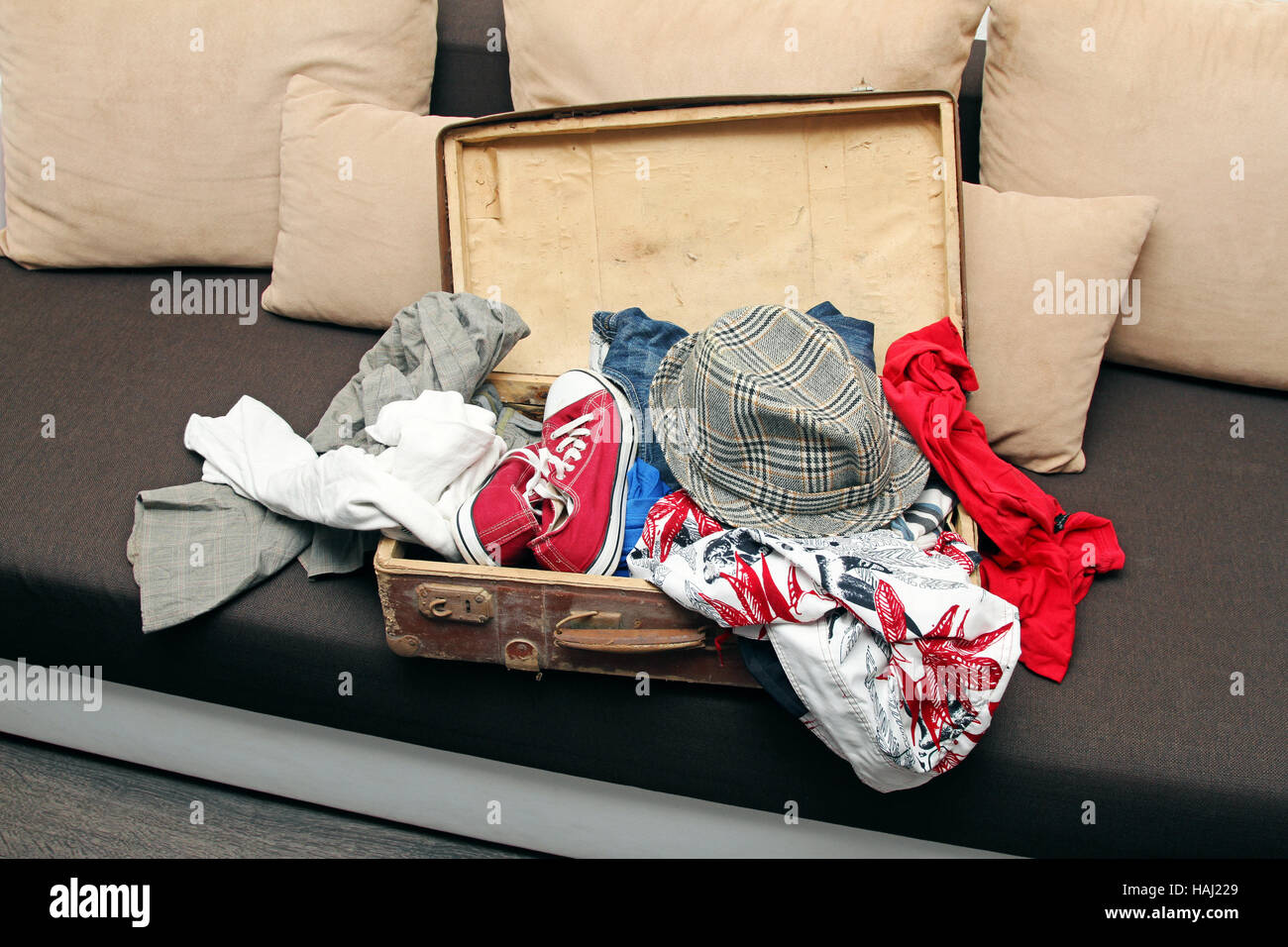 geöffneten Koffer voll mit Kleidung auf couch Stockfoto