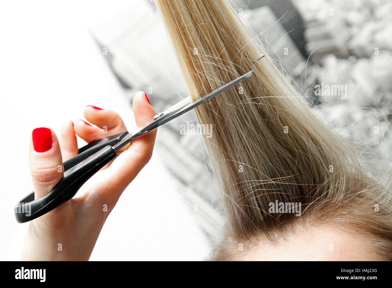 Frau lange Haare mit einer Schere schneiden Stockfoto