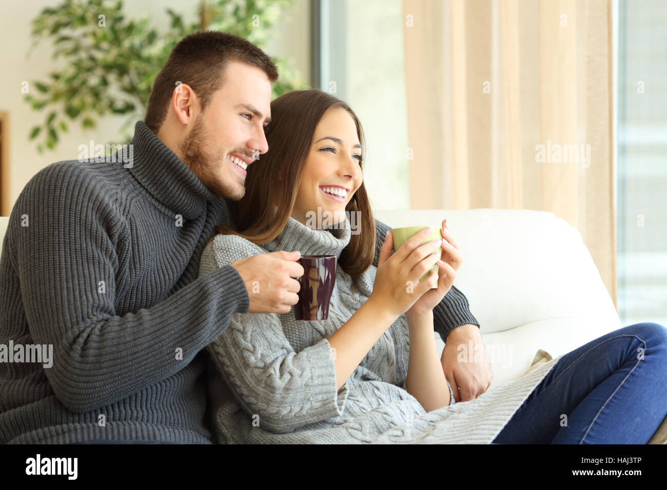Couple cuddling sofa winter -Fotos und -Bildmaterial in hoher Auflösung –  Alamy