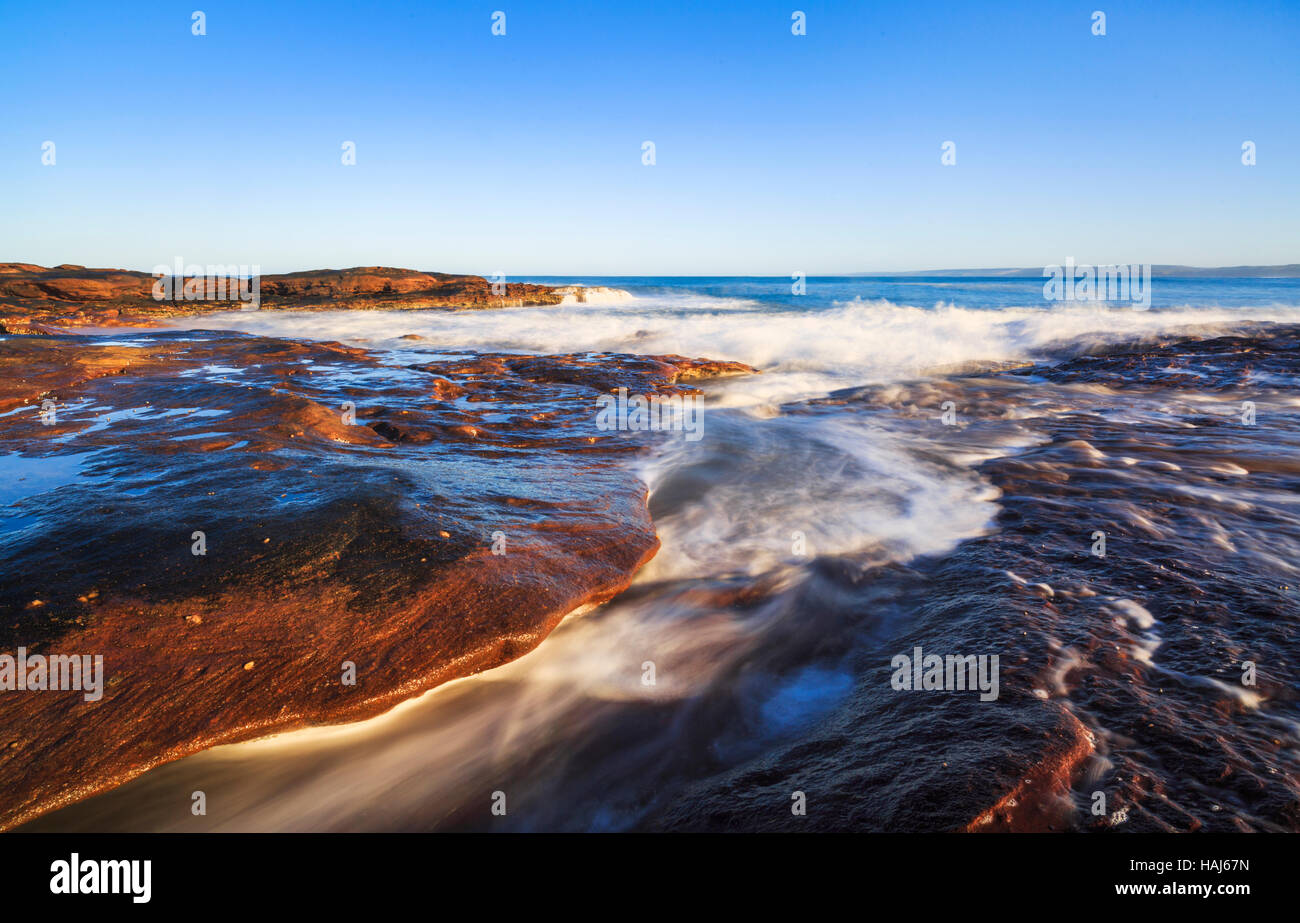 Wellen an der felsigen Sandstein Küste unter Red Bluff im Kalbarri National Park Stockfoto