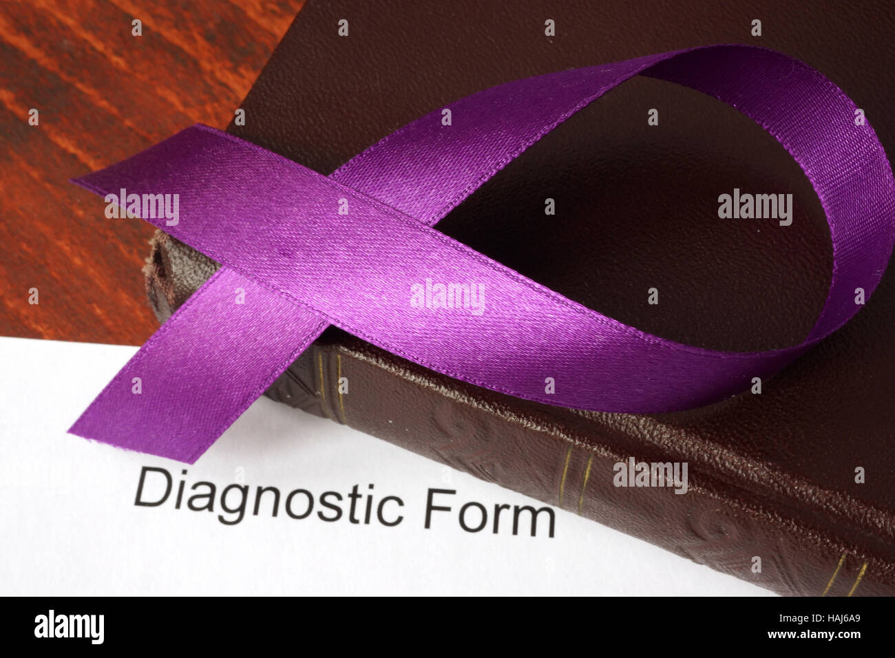 Diagnose von Bauchspeicheldrüsenkrebs.  Lila Schleife an einem Buch. Stockfoto