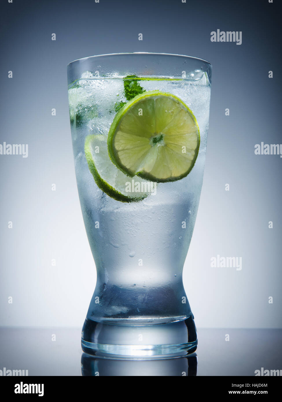 Kühlen Drink mit Eis, Zitrone, Minze auf einem grauen Hintergrund Stockfoto