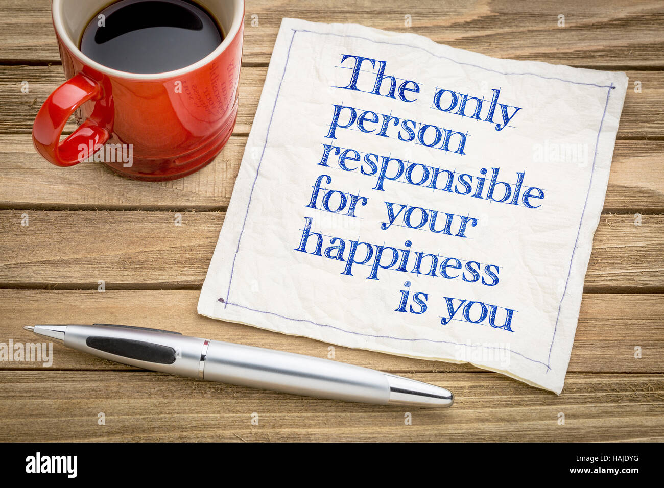 Die einzige Person, die für Ihr Glück verantwortlich ist, dass Sie - inspirierende Handschrift auf einer Serviette mit einer Tasse Kaffee Stockfoto