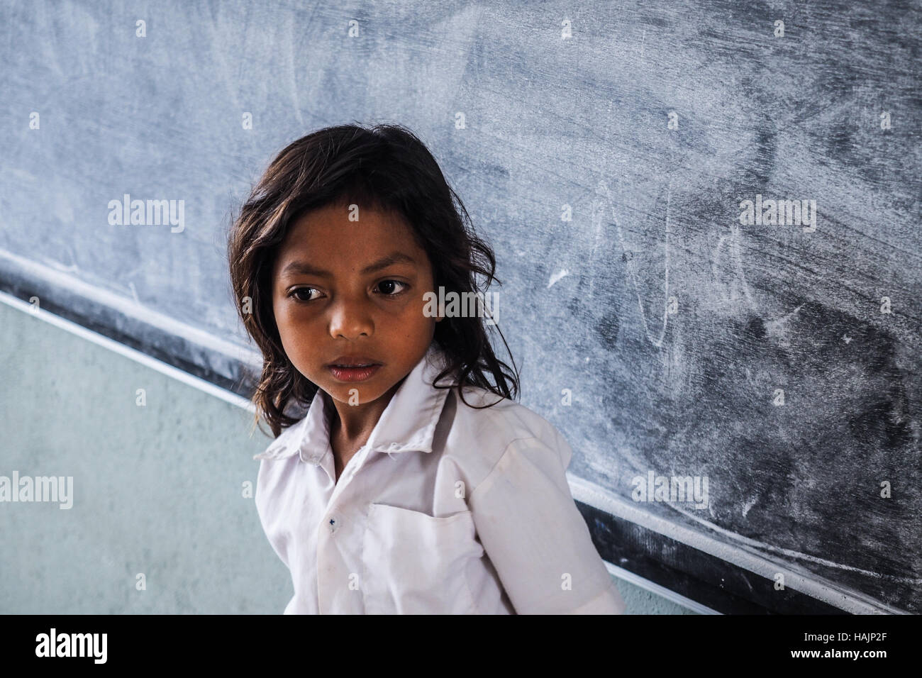 Studentin vor schmutzigen Tafel in armen Klassenzimmer. Stockfoto