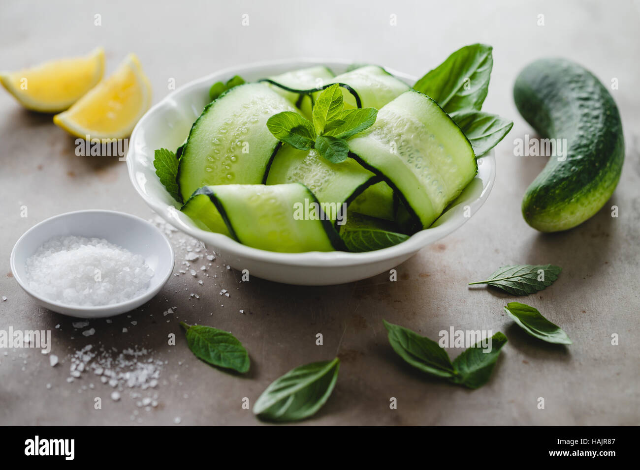 Schüssel mit frischen Gurken und Minze-Salat mit Meersalz und Zitrone Stockfoto