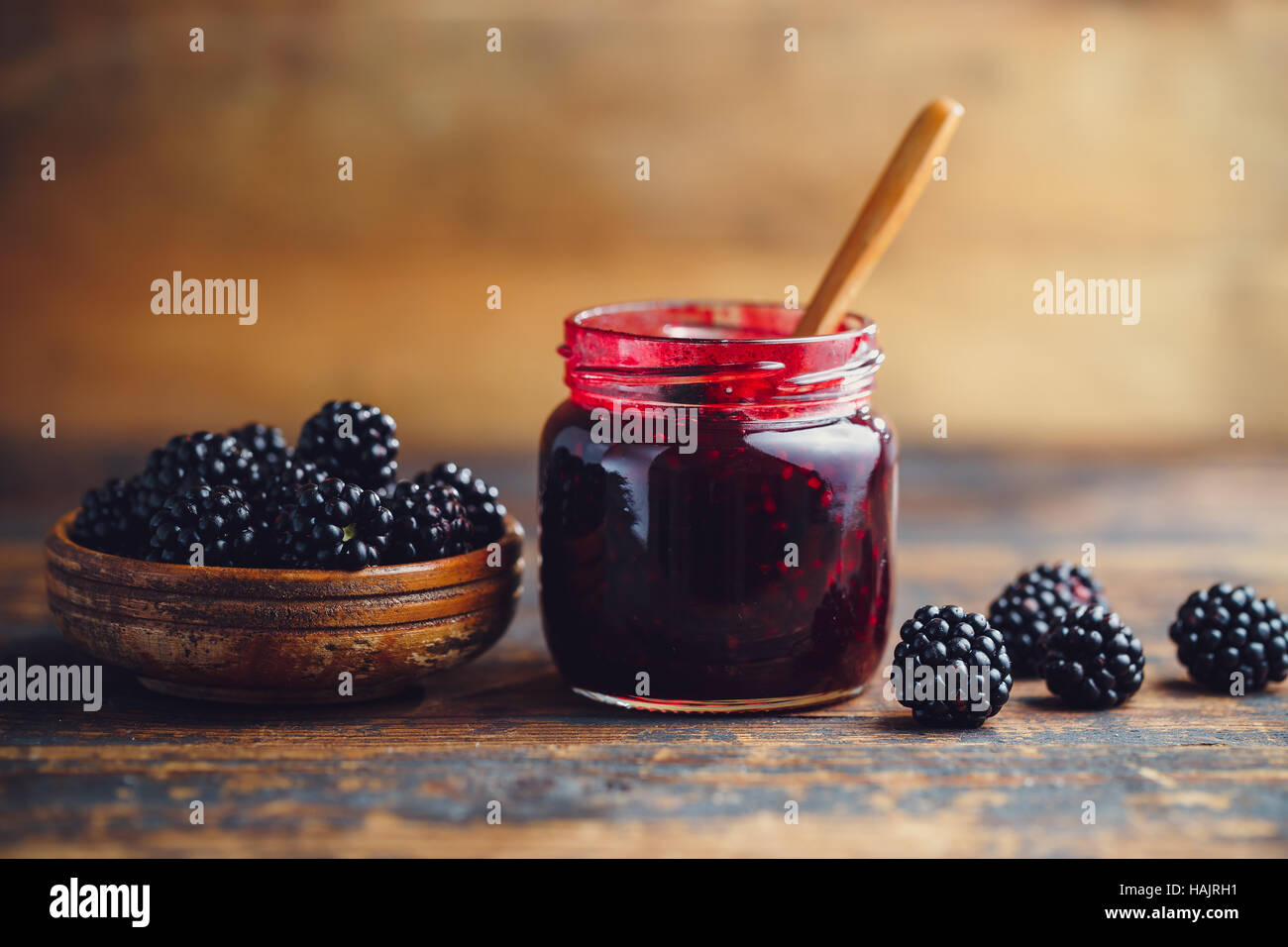 Frische hausgemachte Brombeermarmelade in Glas auf einem hölzernen Hintergrund Stockfoto