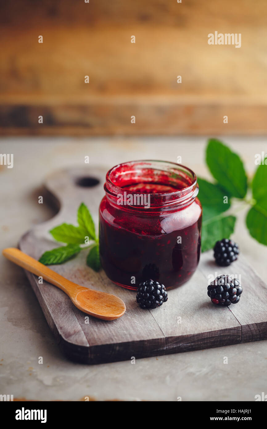 Frische hausgemachte Brombeermarmelade in Glas auf einem hölzernen Hintergrund Stockfoto