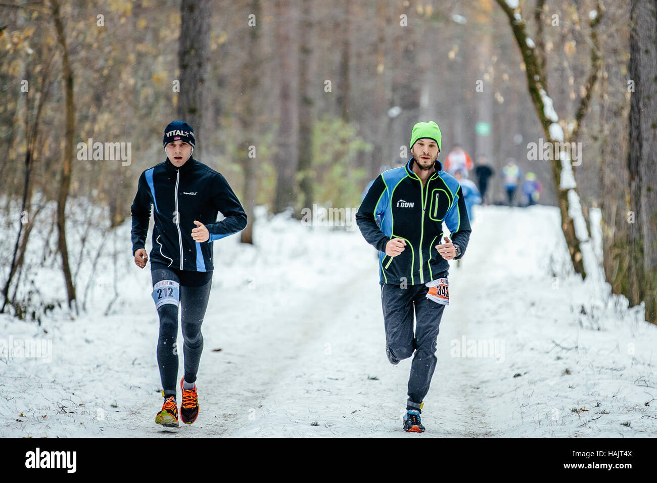 zwei junge Sportler Läufer laufen im Schnee trail Wald im Winter-marathon Stockfoto