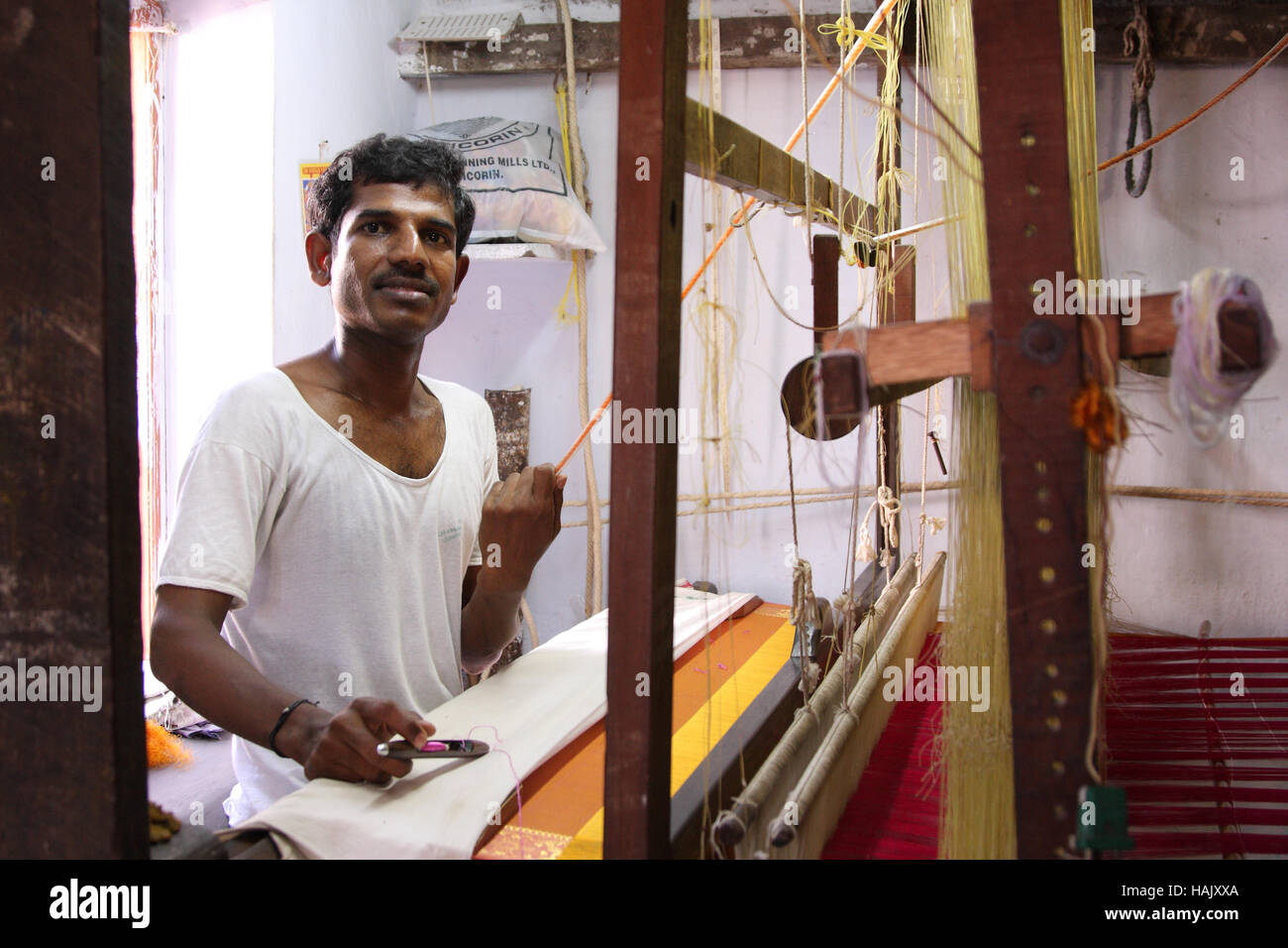Ein Mann, der berühmte Kanchipuram Sari weben, Webstuhl (Handwebstuhl) angetrieben mit einem manuellen Stockfoto