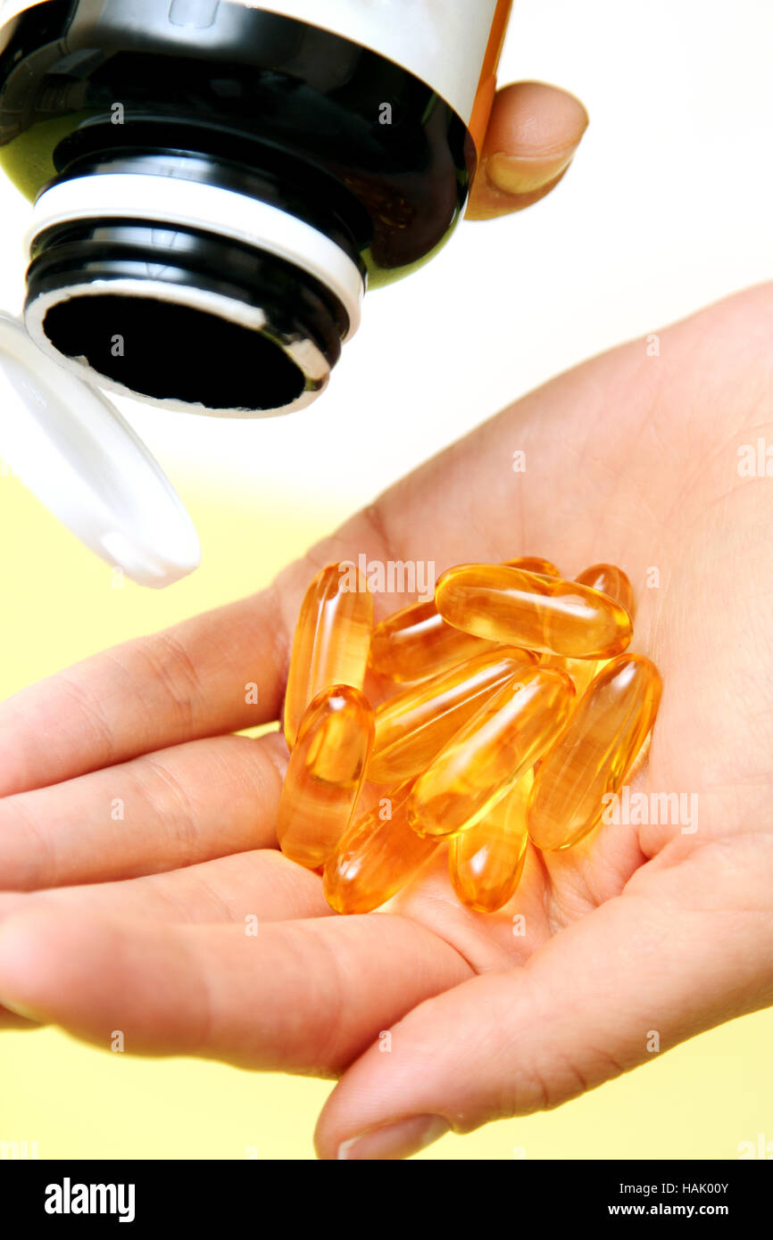 Hand nehmen Vitamin Omega-3 Fischölkapseln auf einer hand Stockfoto