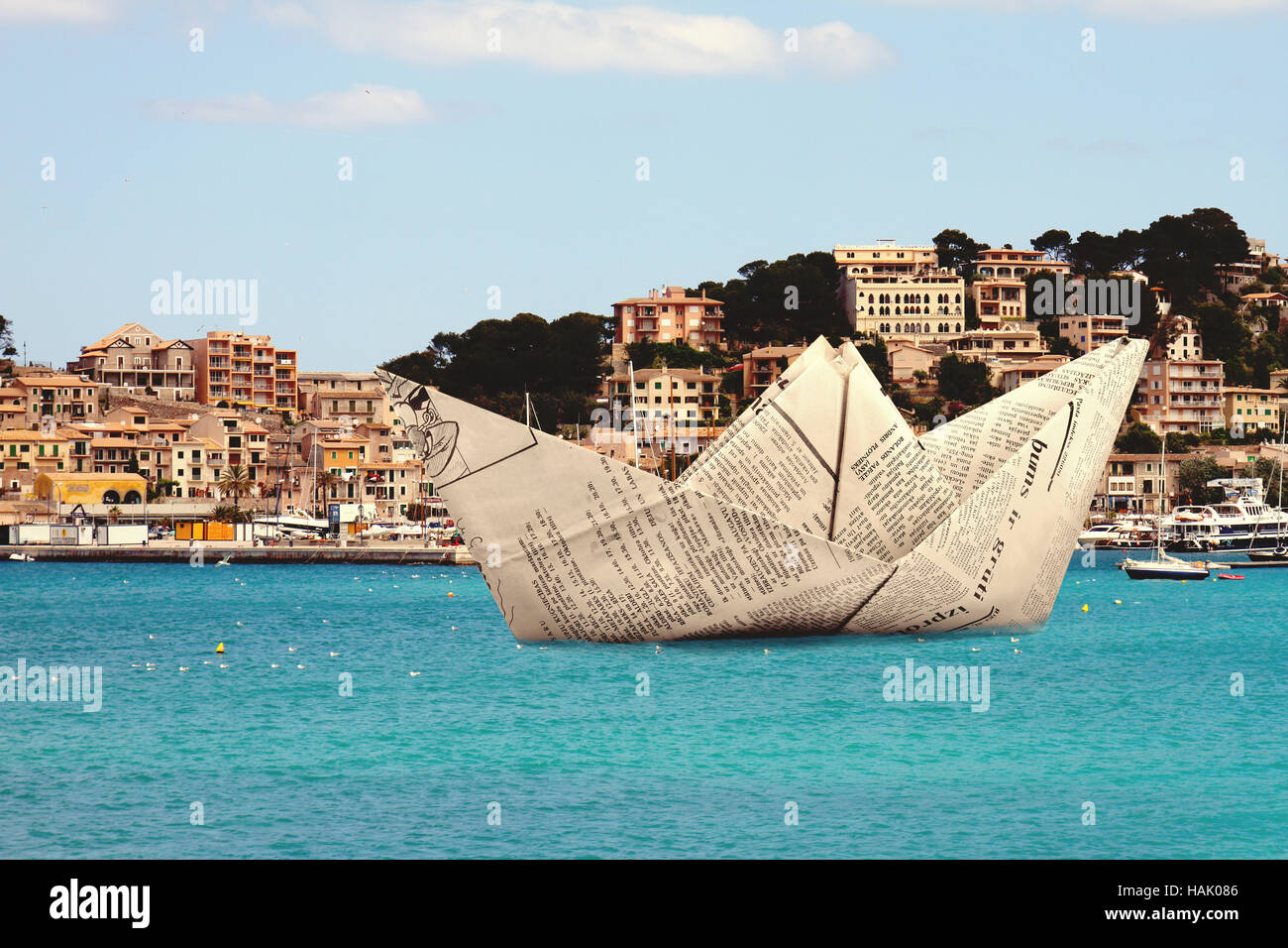 Papierschiff Origami schweben im Wasser in der Nähe von port Stockfoto