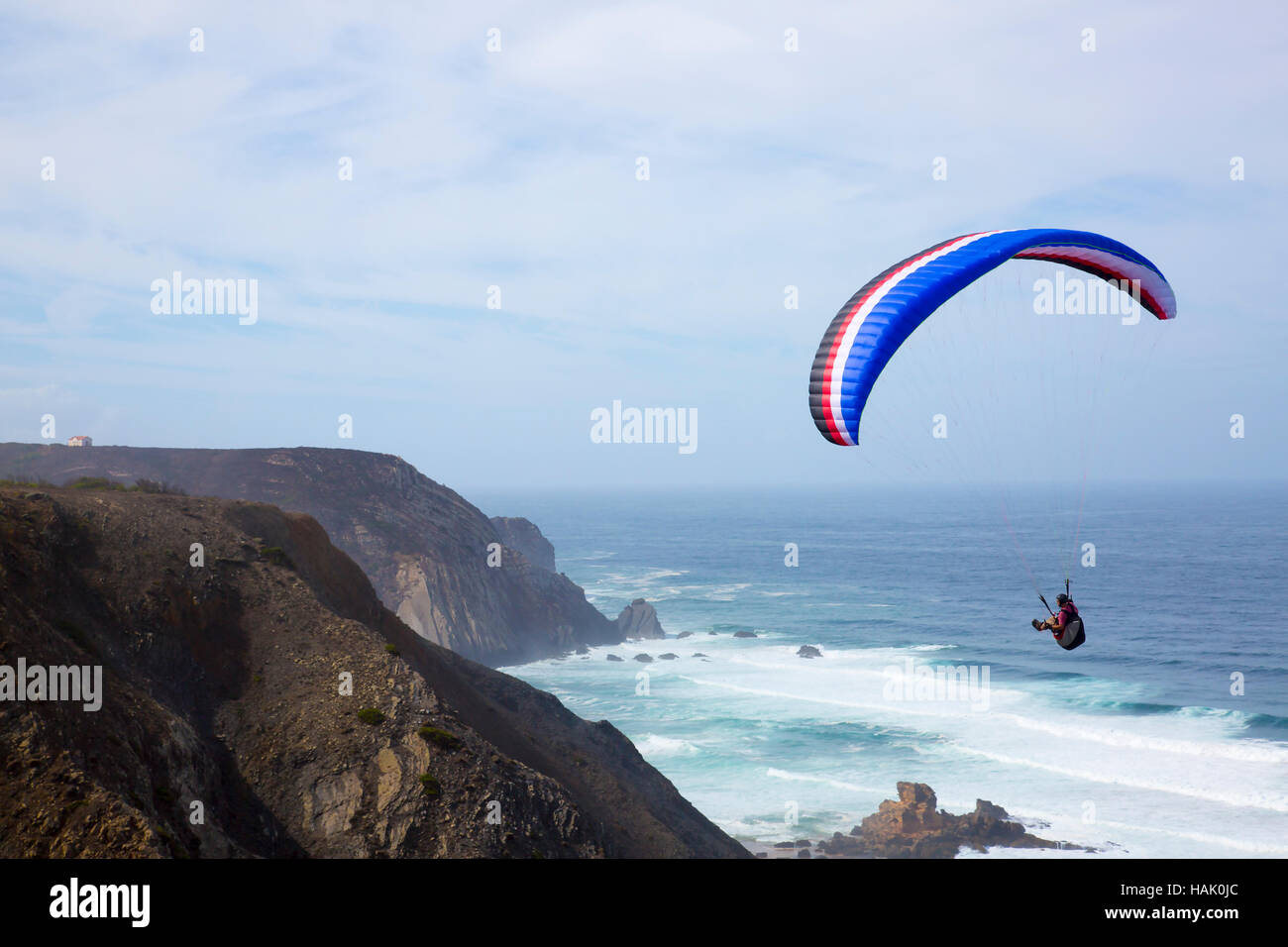 Gleitschirmfliegen über dem Ozean am Castelejo Strand in Portugal Stockfoto