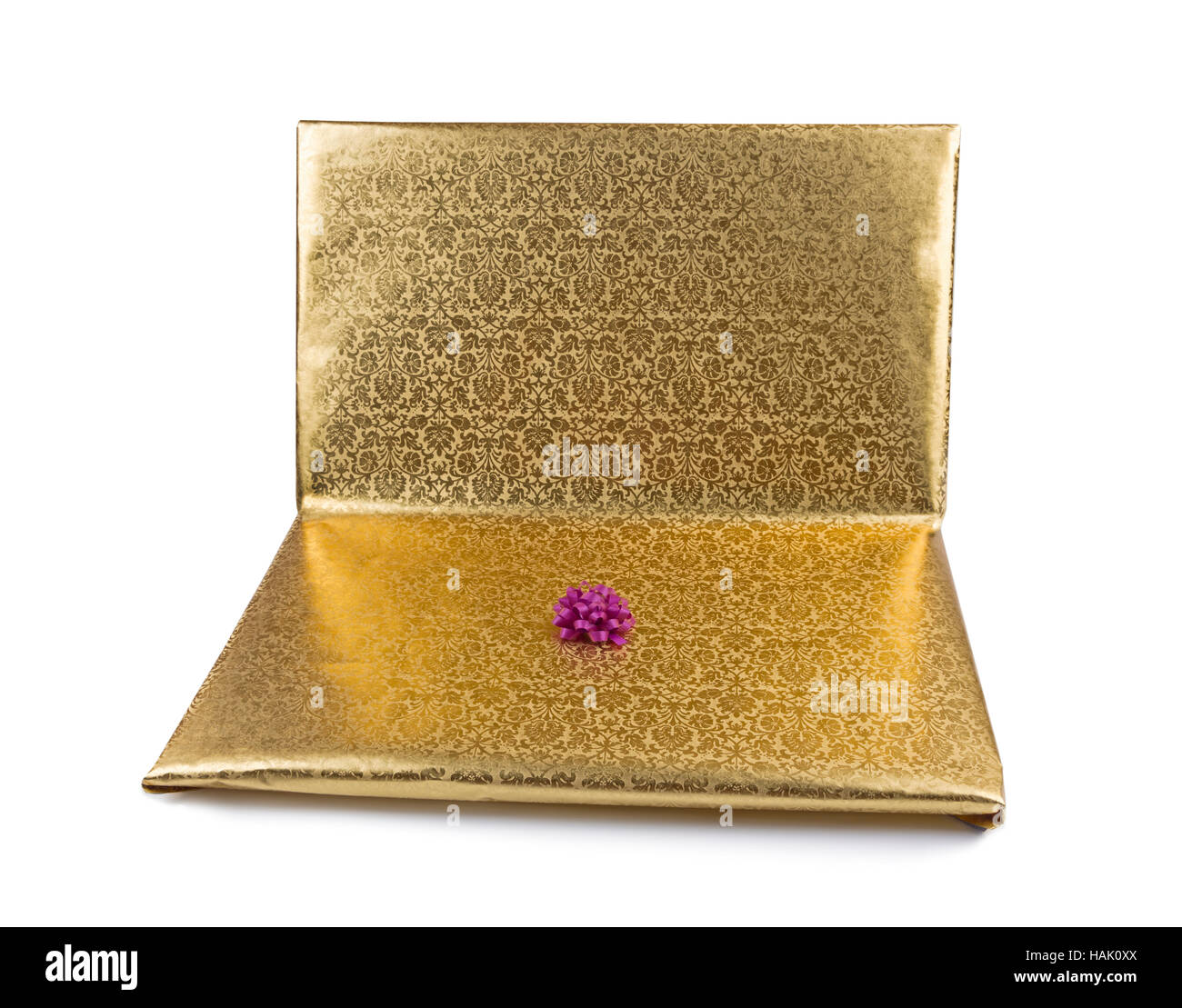 Laptop in goldene Geschenkpapier isoliert auf weiss gehüllt Stockfoto