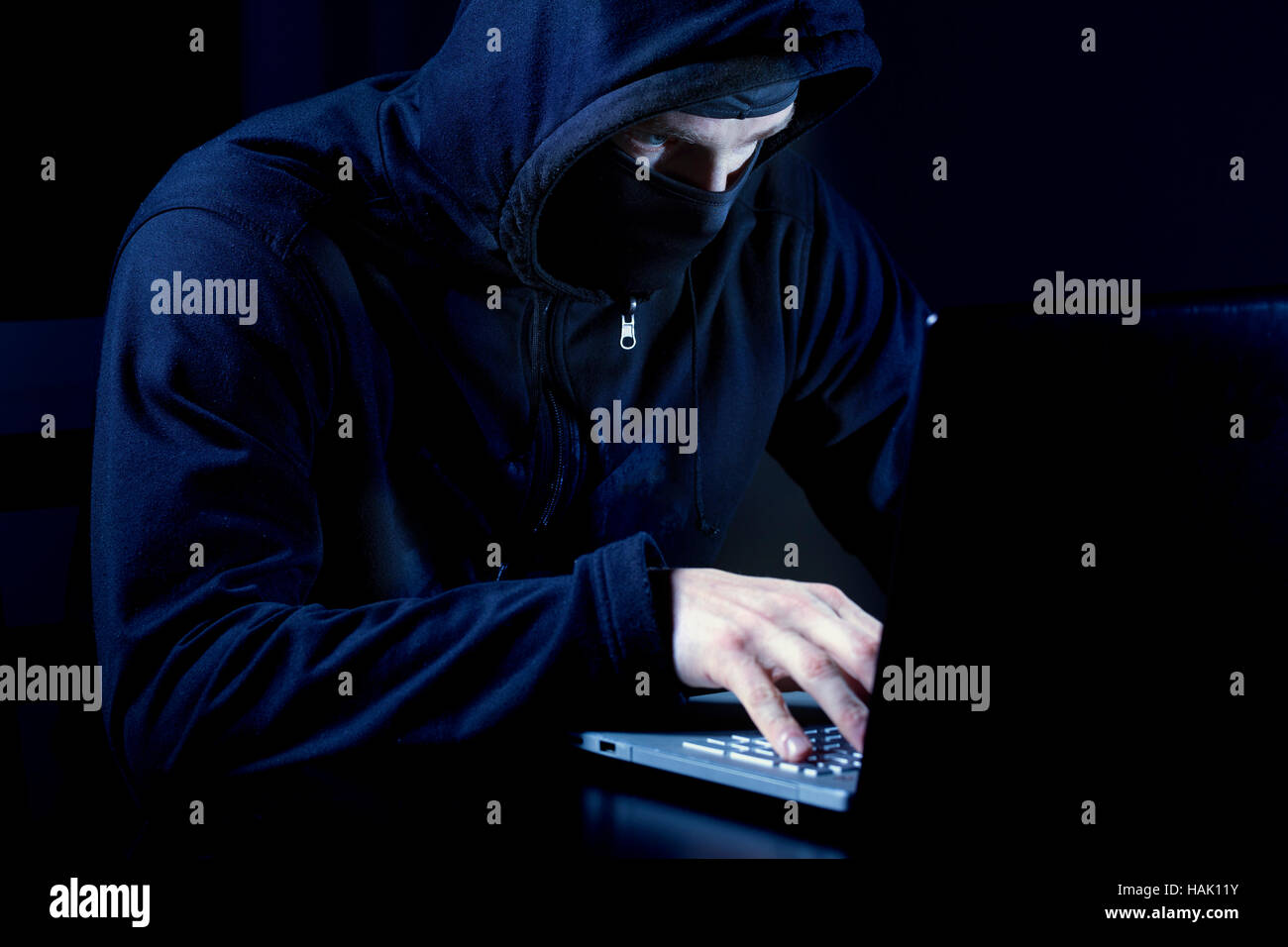 Hacker mit Maske mit Laptop-computer Stockfoto