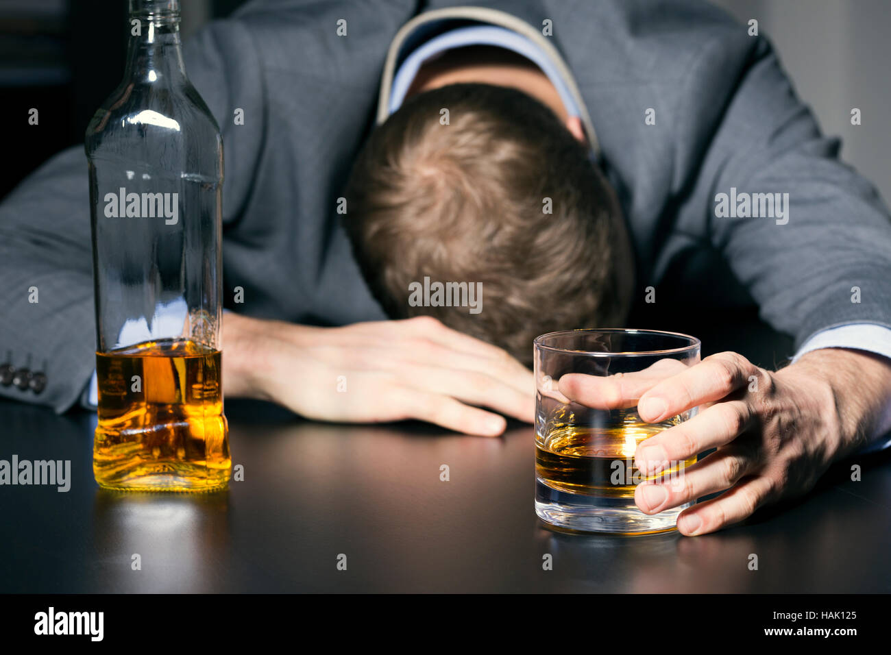 Alkoholsucht - betrunken Geschäftsmann mit einem Glas Whisky Stockfoto