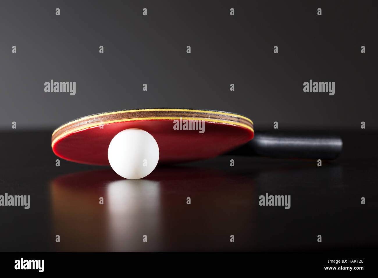 Ping-Pong-Schläger und Ball auf dunklen Tisch Stockfoto