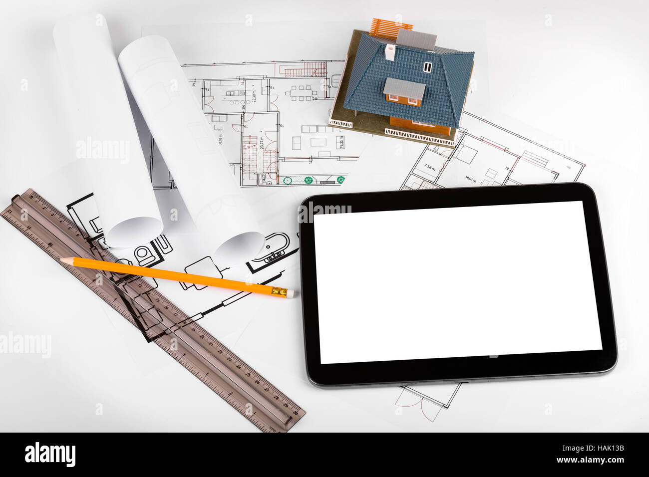 leere Tablet und Haus Maquette auf Architekturpläne Stockfoto