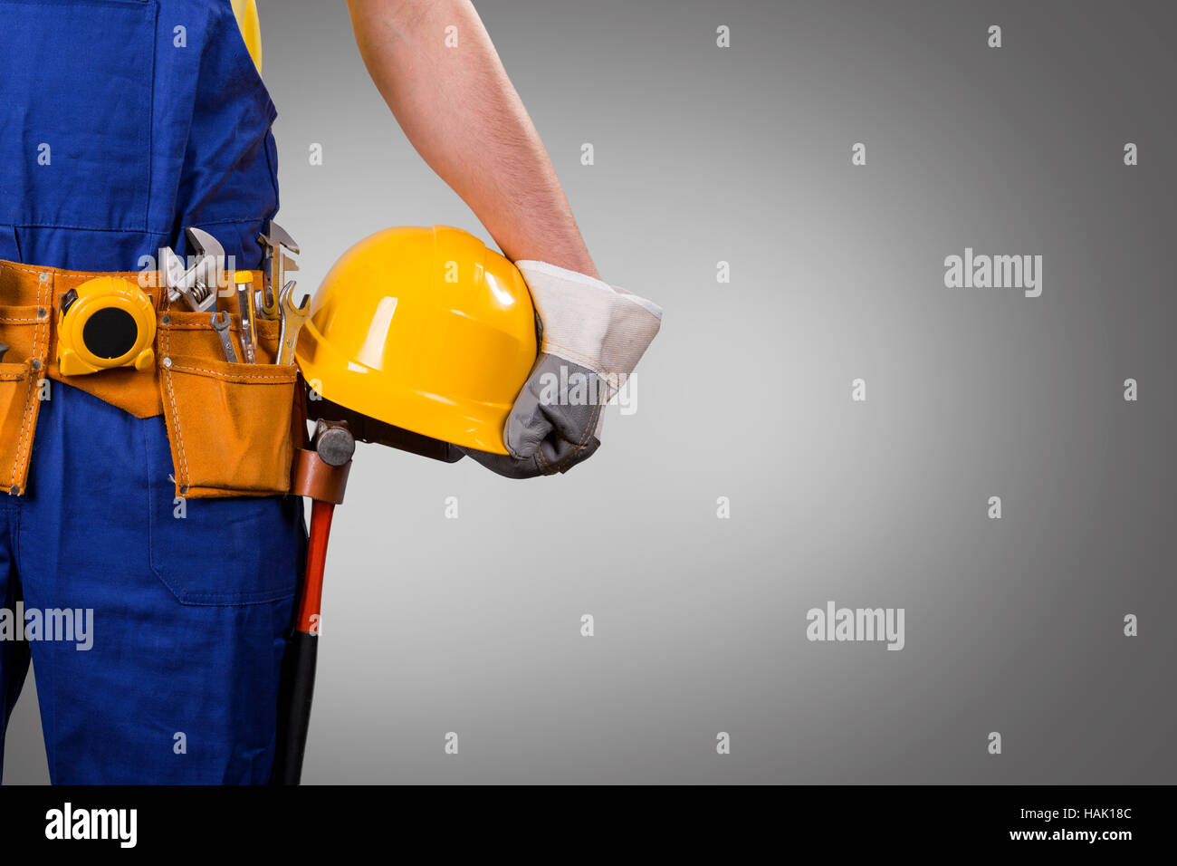 Bauarbeiter mit Helm auf grauem Hintergrund mit Textfreiraum Stockfoto